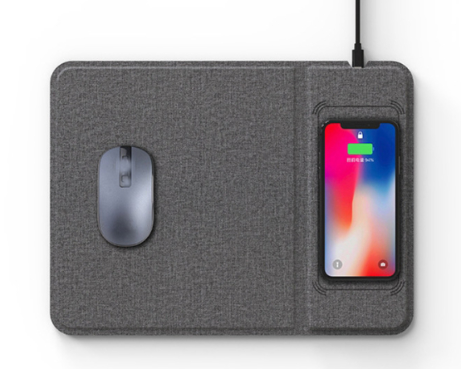 Graues Mauspad mit einer kabellosen Maus und einem darauf ladenden Telefon.