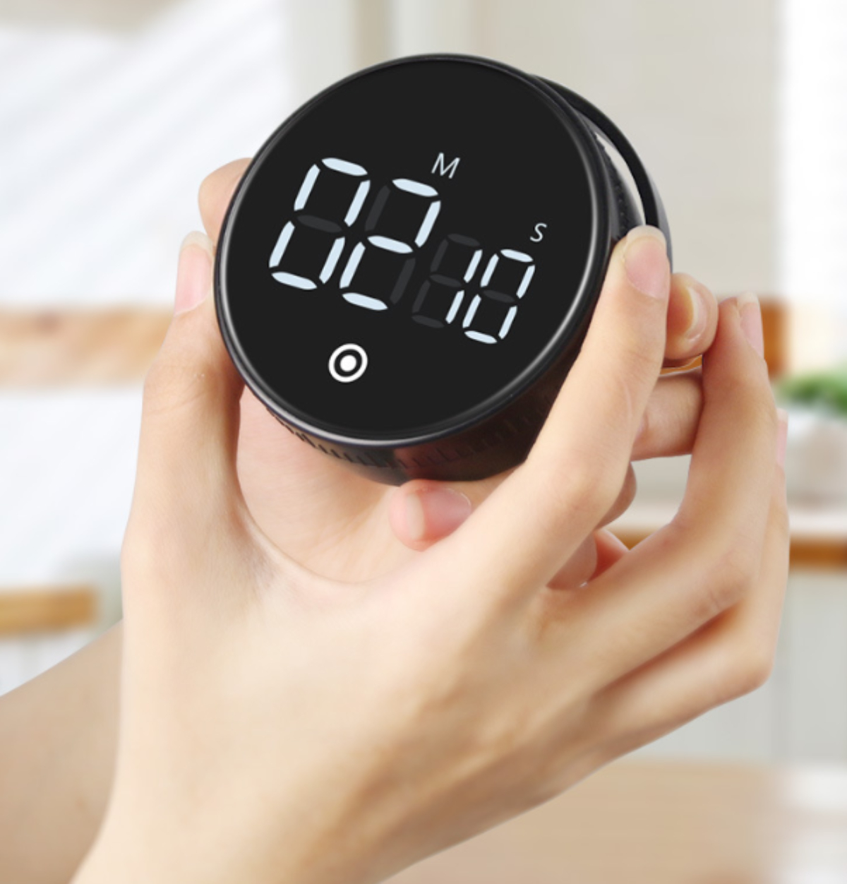 Ein schwarzer Timer mit digitaler Anzeige wird von zwei Händen gehalten.
