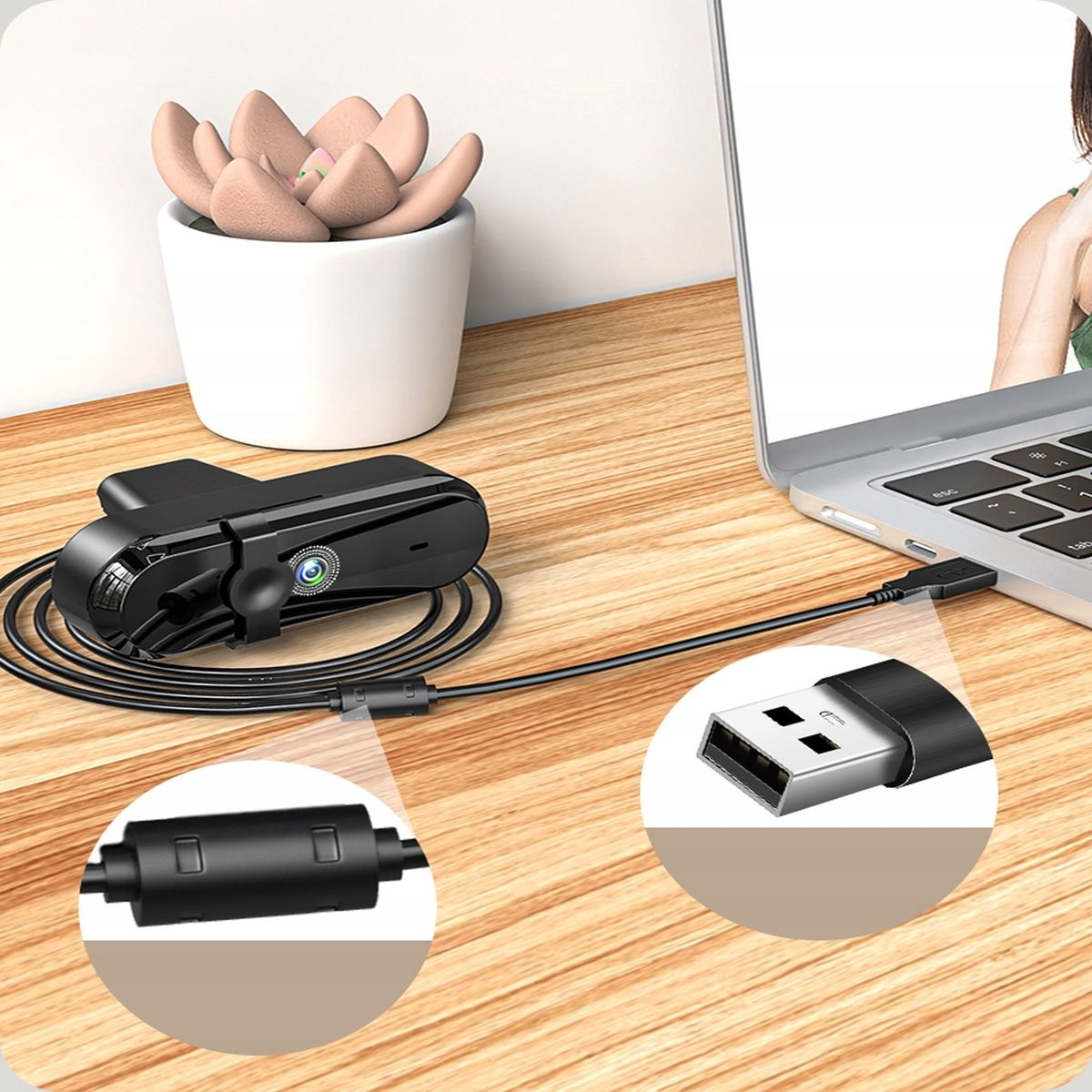 Kamera internetowa, podłączona do laptopa za pomocą kabla USB, obok małej rośliny.