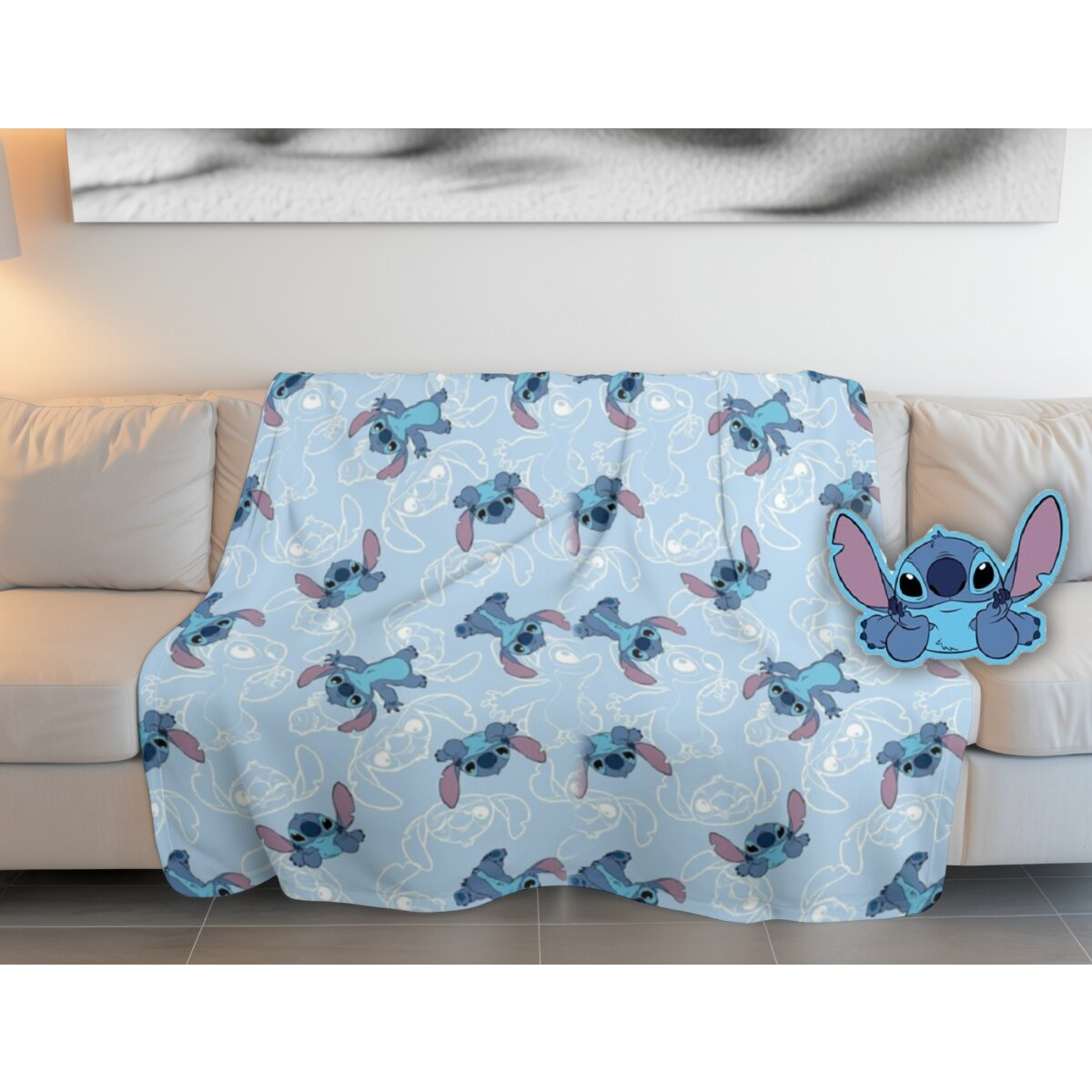 Blaue Decke auf einer Couch mit Stitch-Muster. Stitch-Kissen daneben.