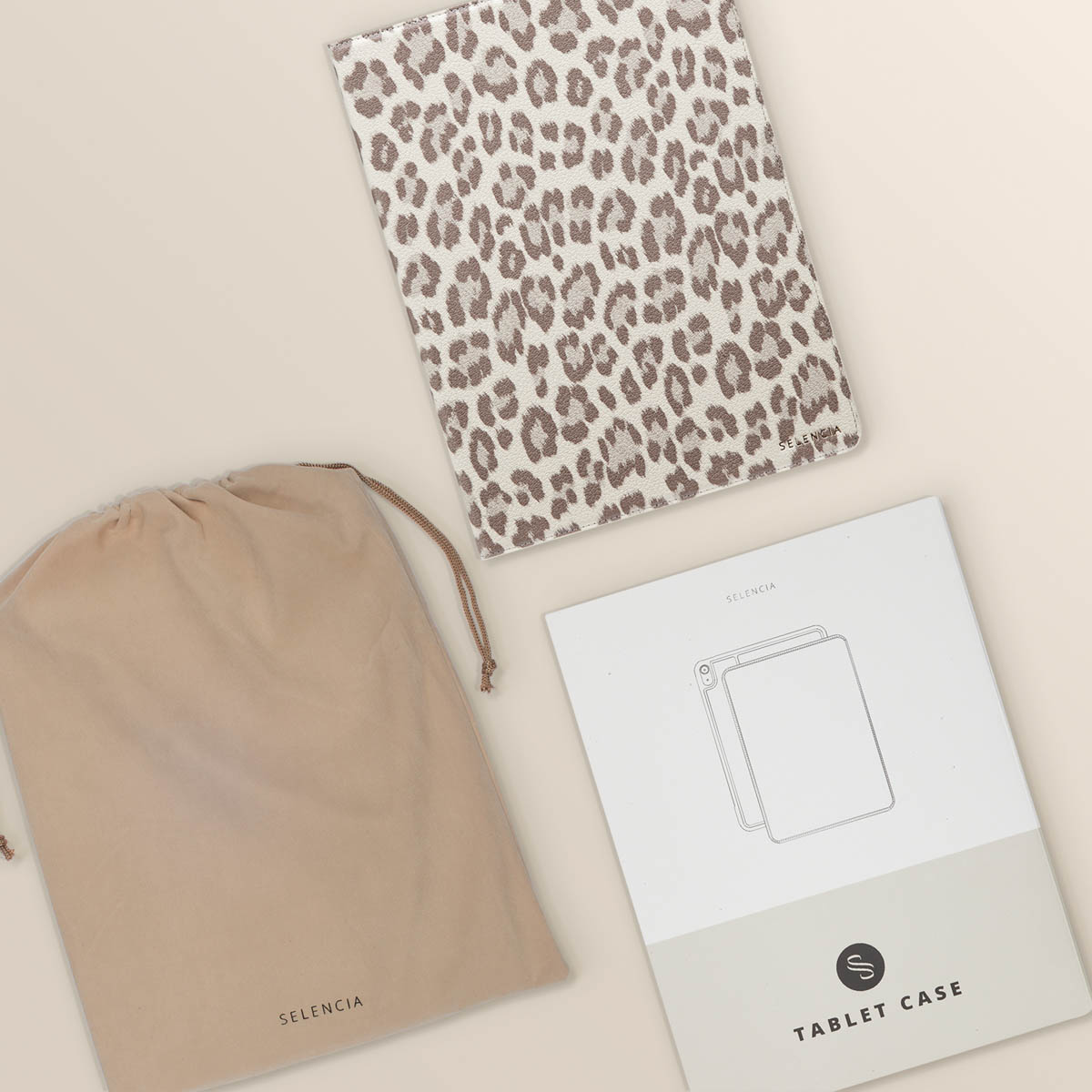 Leopard print tablet cover, a bag and a tablet case manual on a light background.