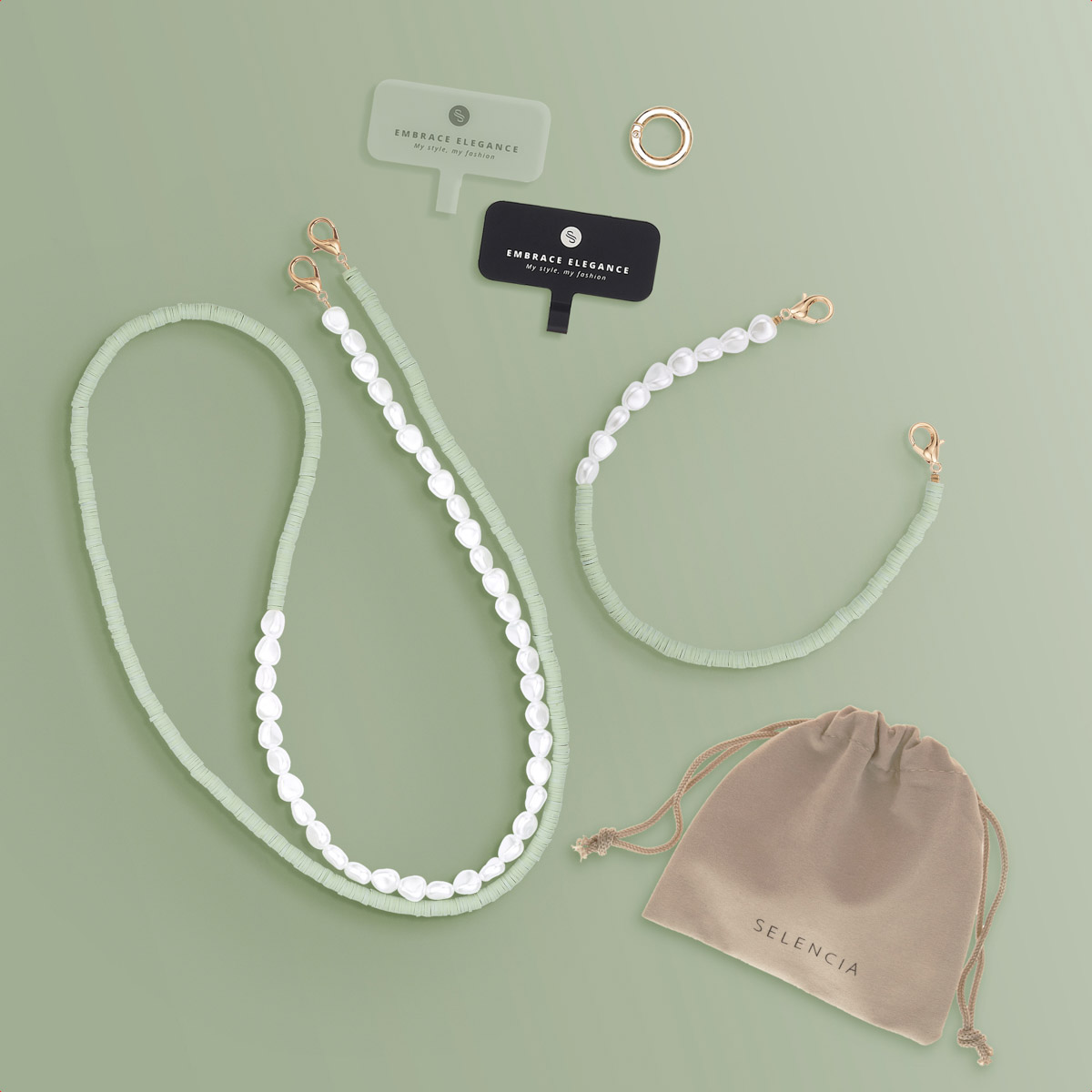 Cinturini e accessori per telefoni su sfondo verde. Include perle, connettori e un sacchetto.
