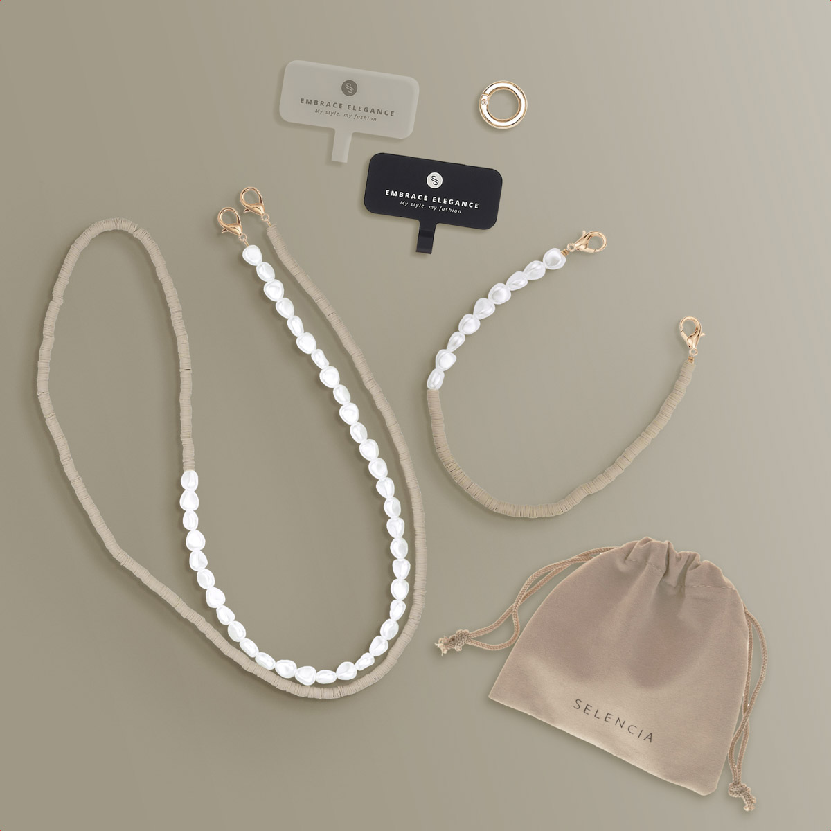 Collane, borsetta ed etichette su una superficie beige. Le collane hanno perle e chiusure dorate.