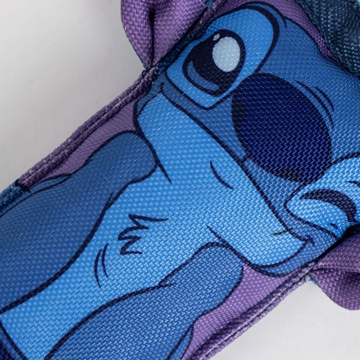 Primo piano di un giocattolo di Stitch. Viso blu di Stitch con sfondo viola.