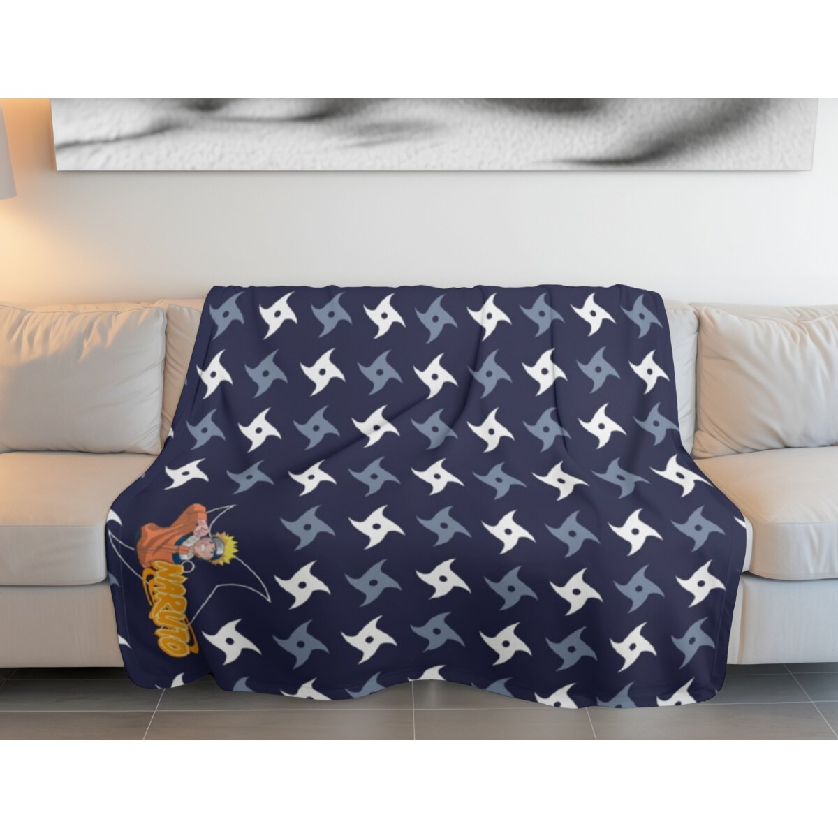 Blaue Decke mit Naruto-Charakteren und Symbolen auf weißem Sofa vor Wand.