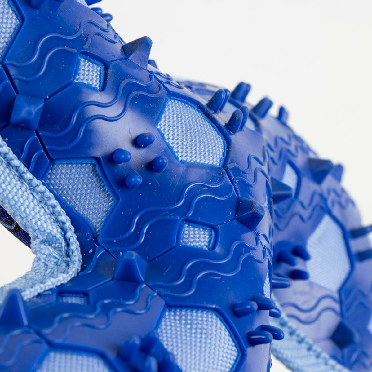 Giocattolo di gomma blu con spuntoni. Primo piano dei dettagli. Design a motivo esagonale.