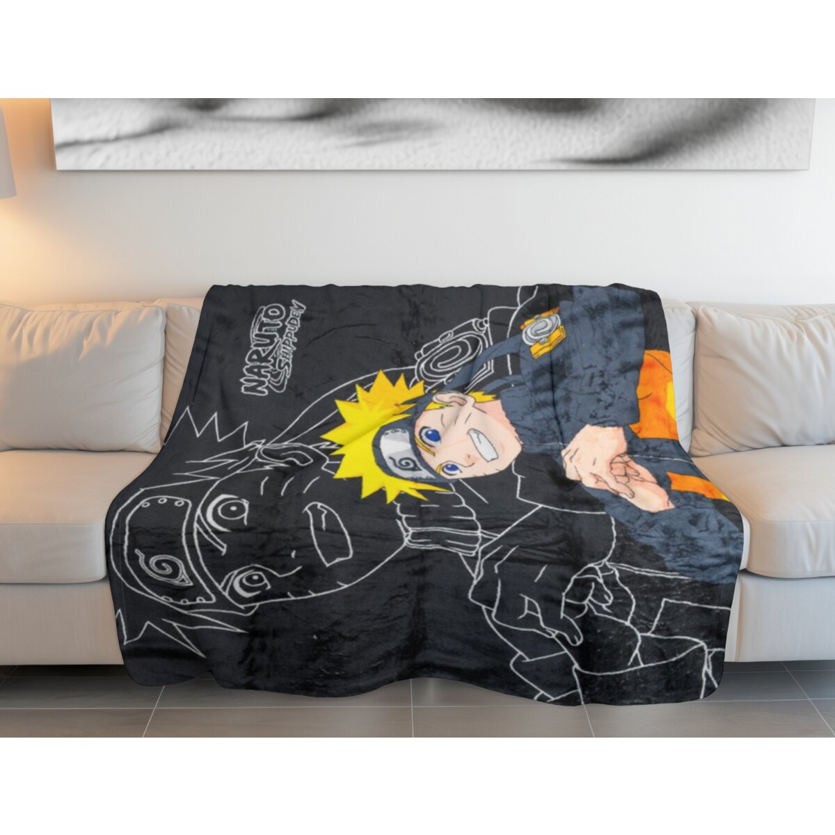 Naruto-Decke auf einer Couch. Zeigt Naruto-Bild. Farben: Schwarz, Weiß, Gelb und Orange. Weißer Hintergrund.