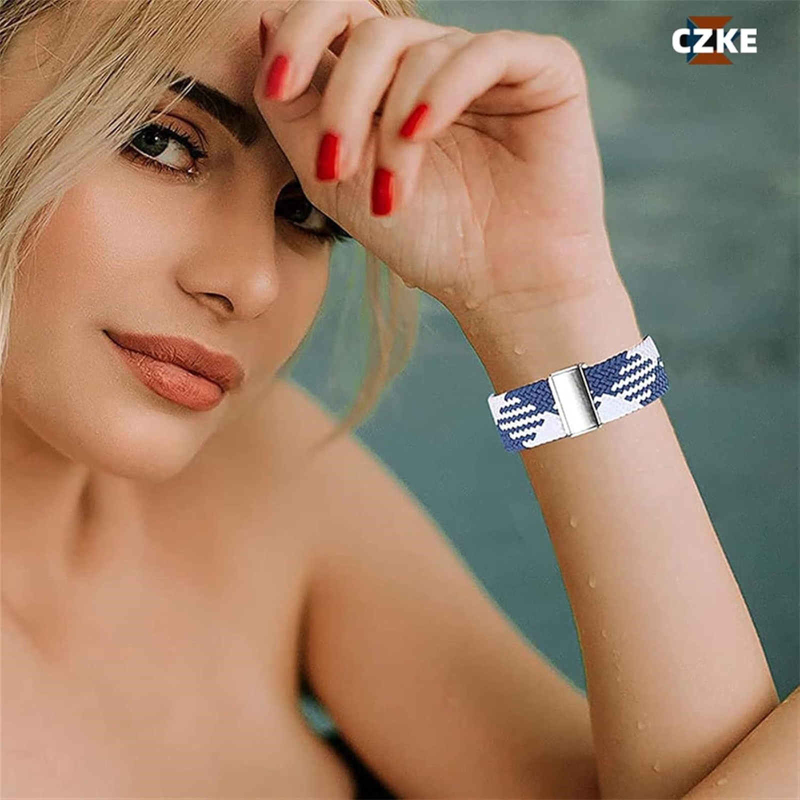 Frau mit blau-weißem Armband mit silbernem Verschluss, roter Nagellack.