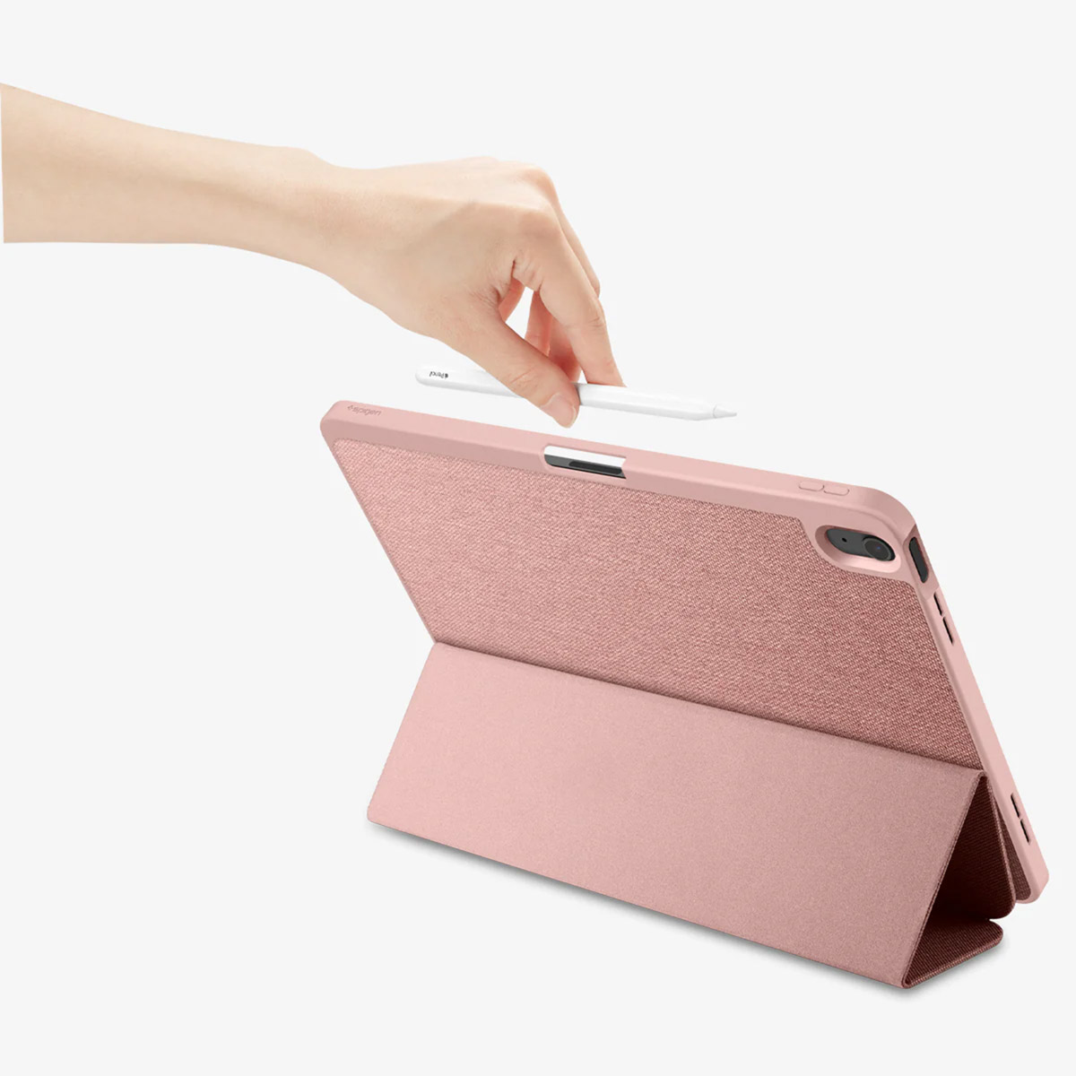 A hand placing a white stylus on a pink tablet case.