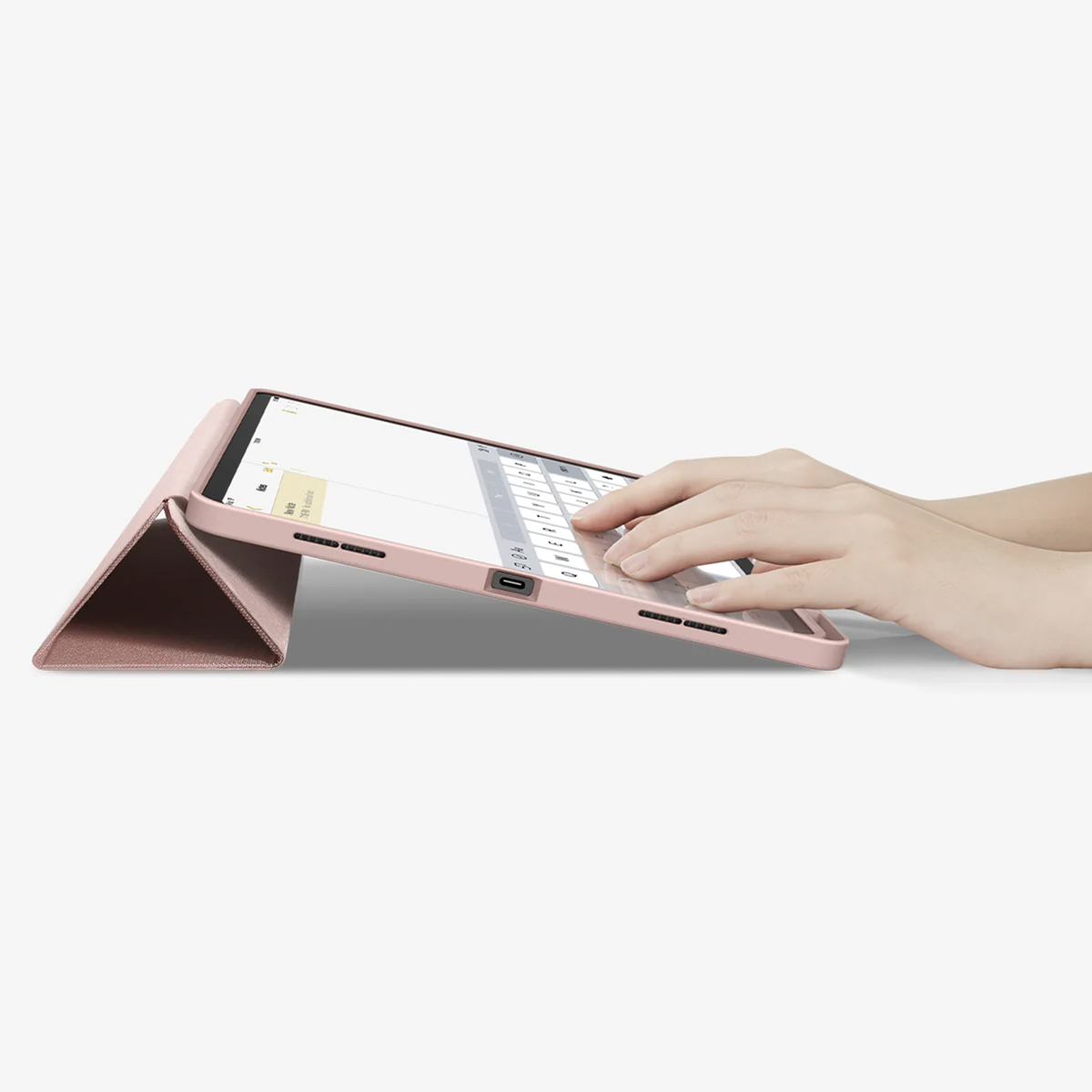 Hands typing on tablet. The tablet is in a pink case.