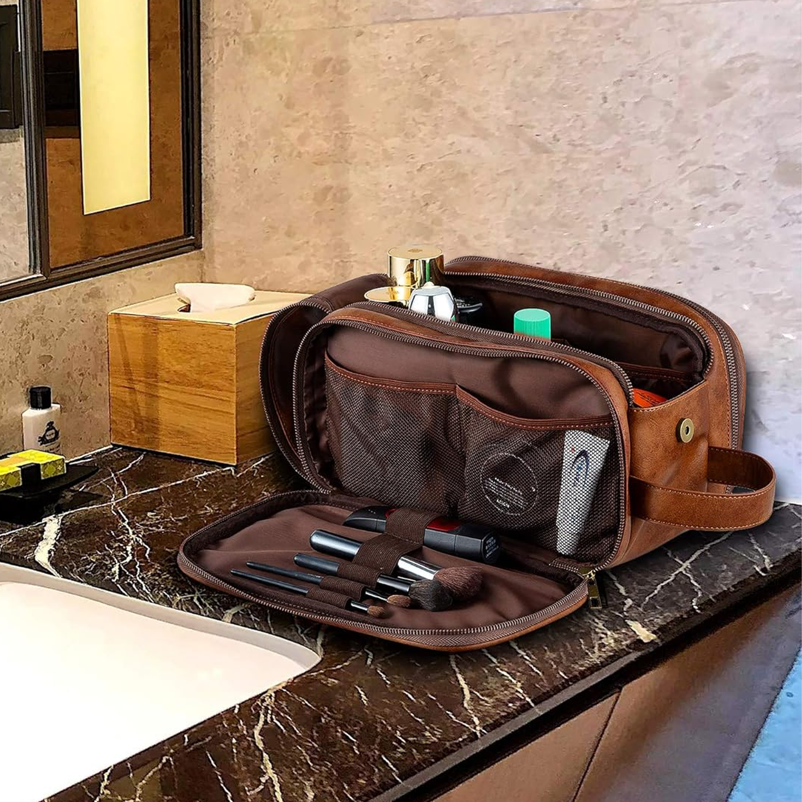 Braune Leder-Kulturtasche offen auf einer Badezimmerablage mit Toilettenartikeln.