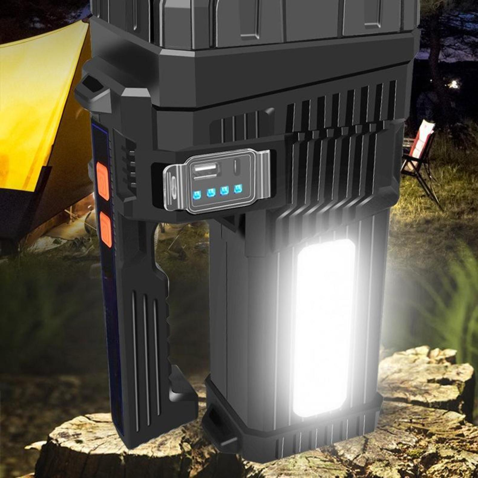 Eine schwarze Taschenlampe mit hellem weißem Licht und orangefarbenen Knöpfen. Im Hintergrund Zelt und Stuhl.