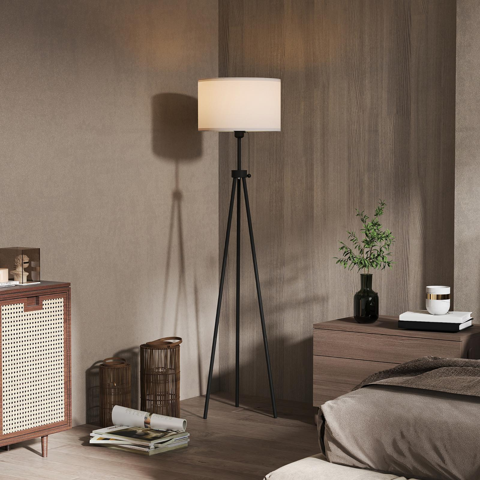 Zimmerinnenraum mit Lampe, Holzschrank und Bett.