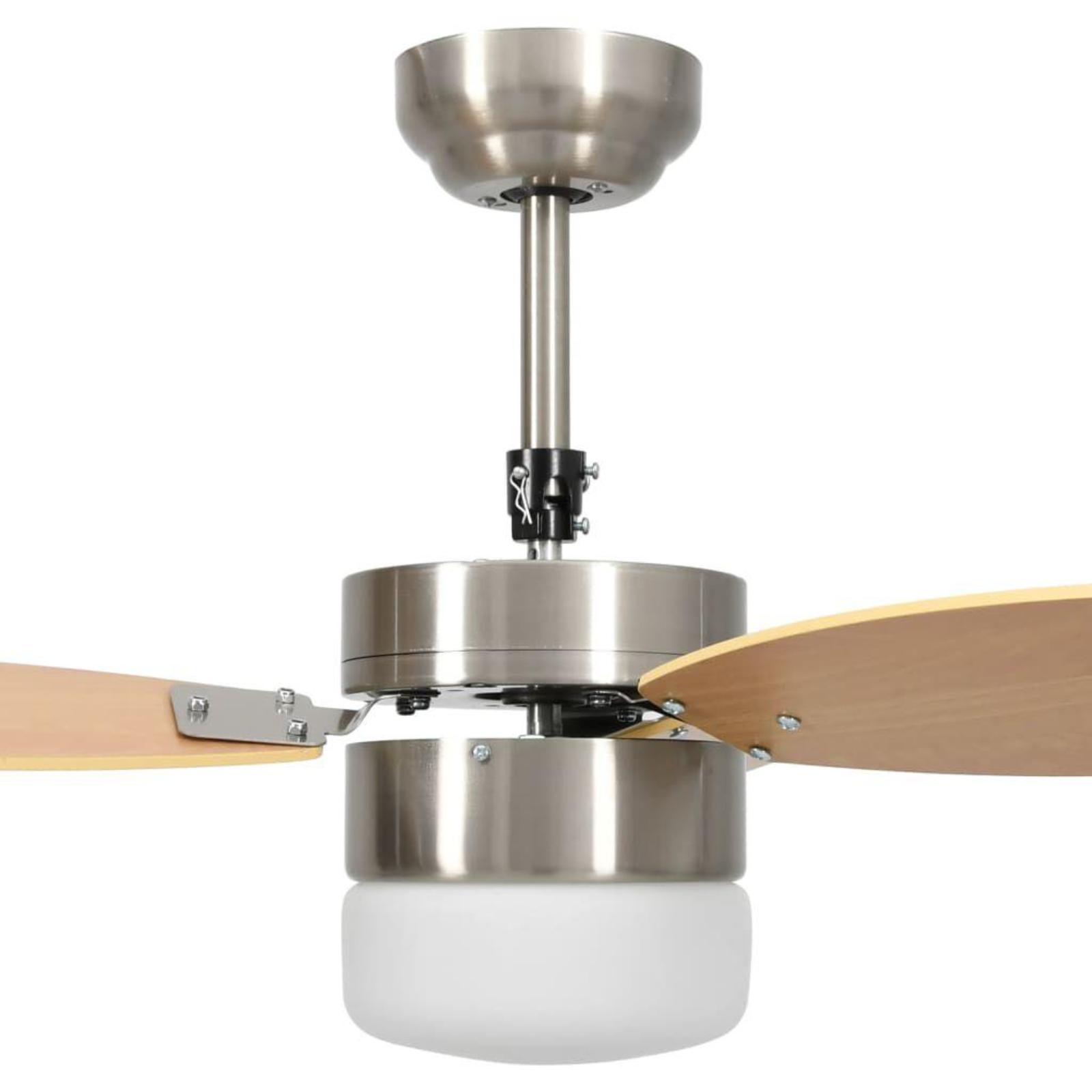 Nahaufnahme eines silbernen Deckenventilators mit hellen Holzflügeln und einer weißen Glasleuchte darunter.