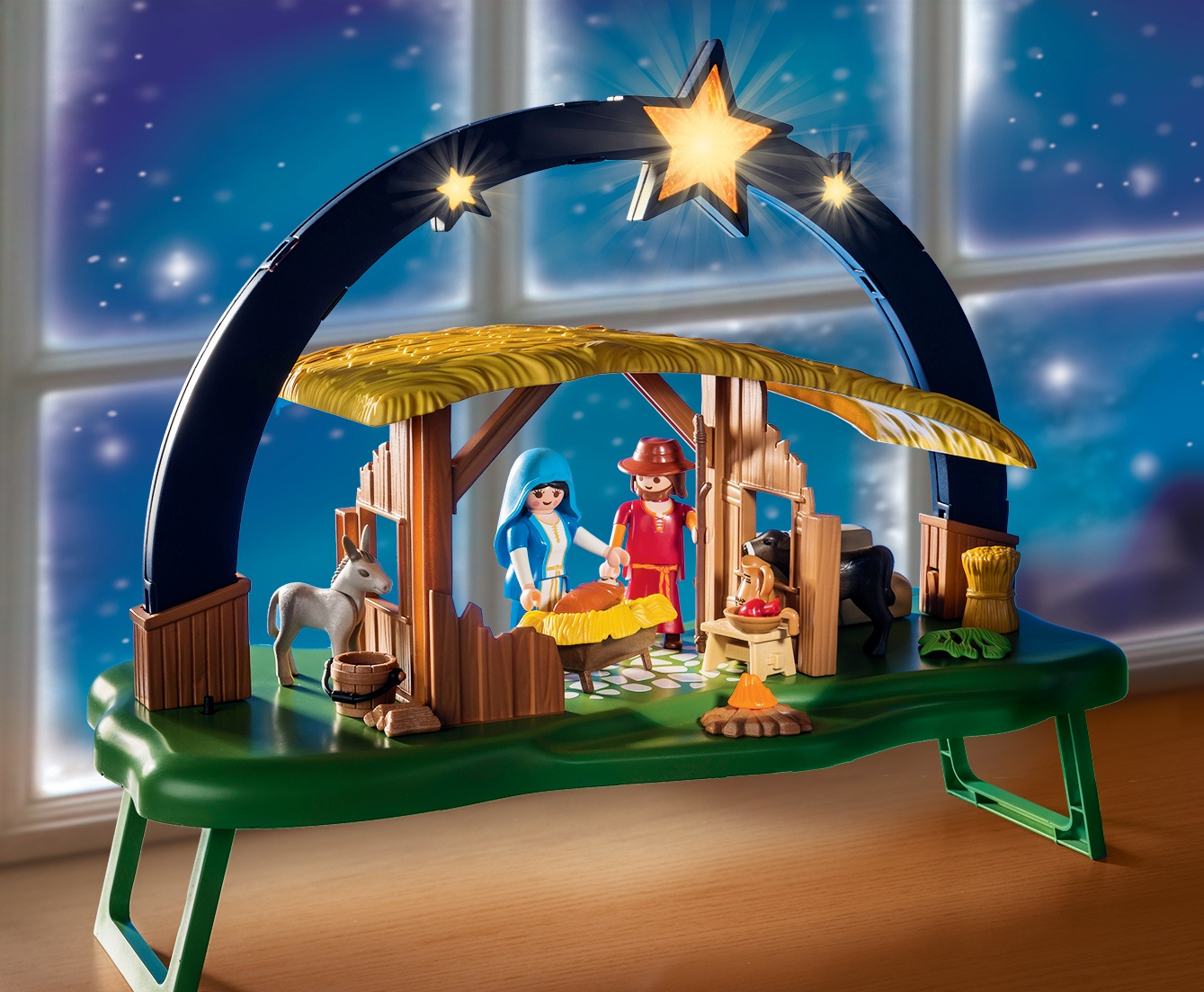 Scena del presepe di Natale Playmobil con personaggi, una stalla e una luce stellare.