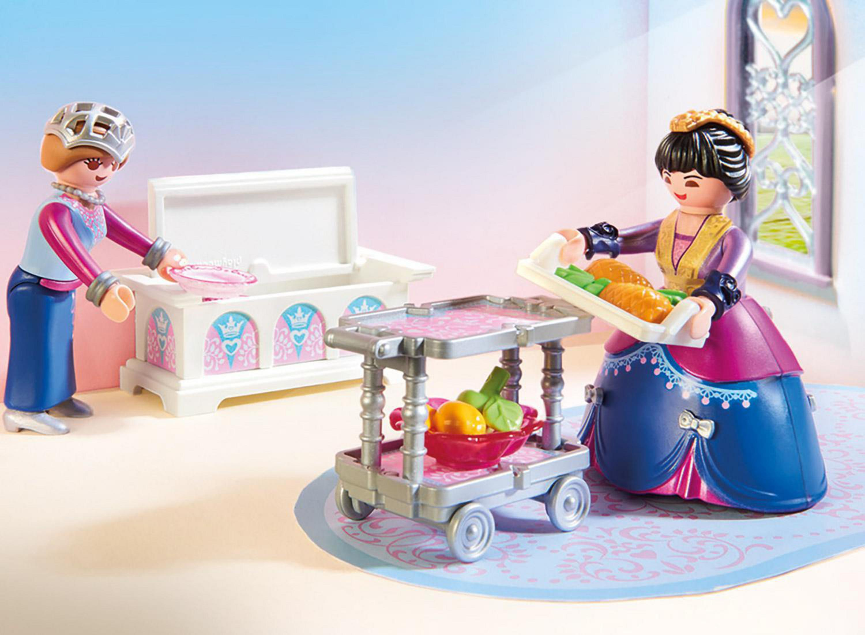 Dos figuras de princesas con carrito de comida y cofre. Una sostiene una bandeja, la otra abre un cofre.