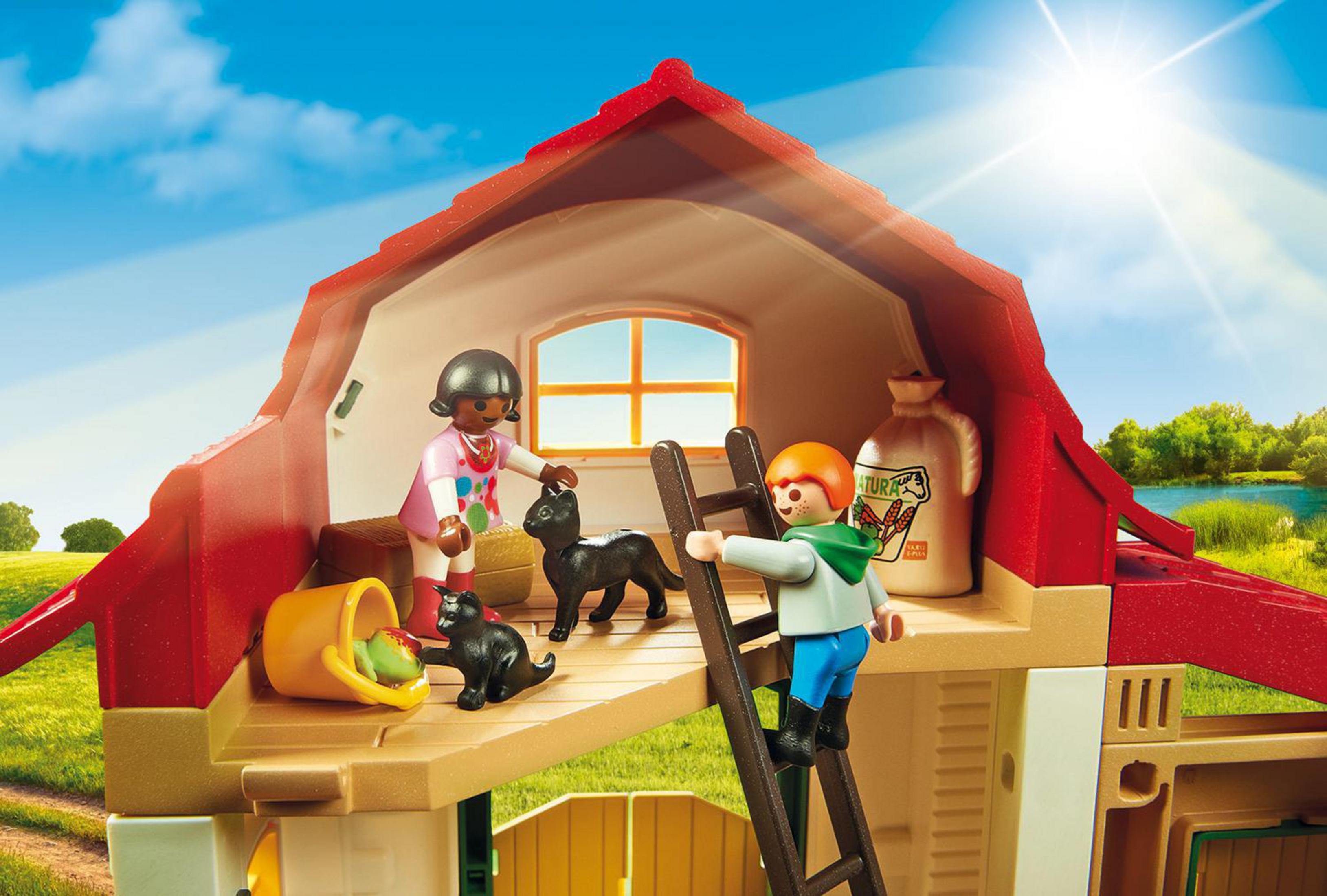 Interno di fienile Playmobil con due figure, un gatto nero, fieno e un bambino che sale una scala sotto un cielo soleggiato.