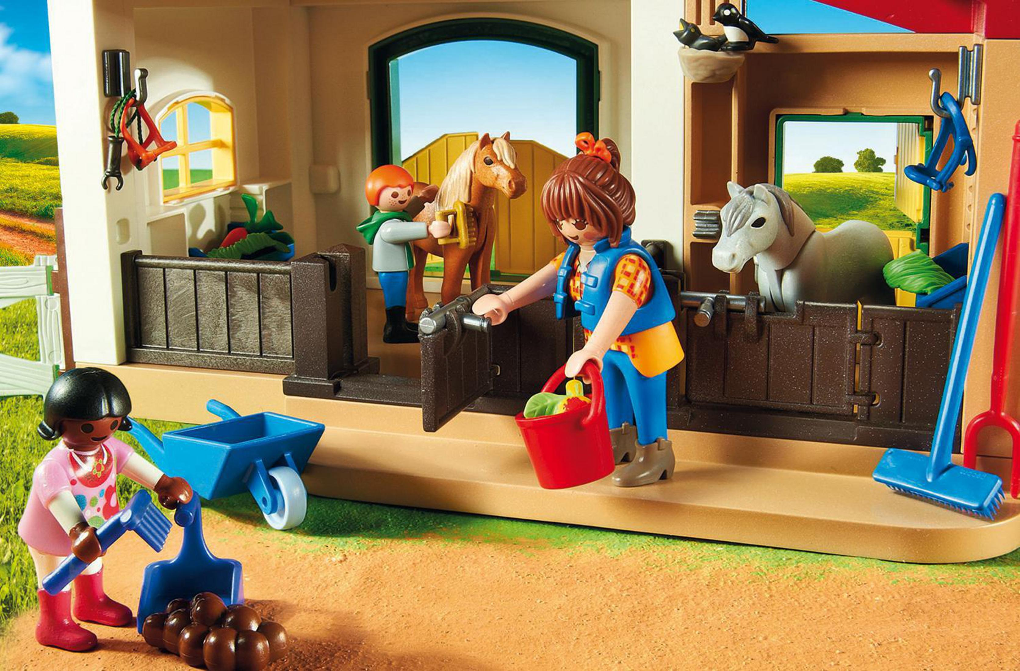 Scena di fienile giocattolo Playmobil. Una donna pulisce con un secchio e una ragazza pulisce il pavimento.
