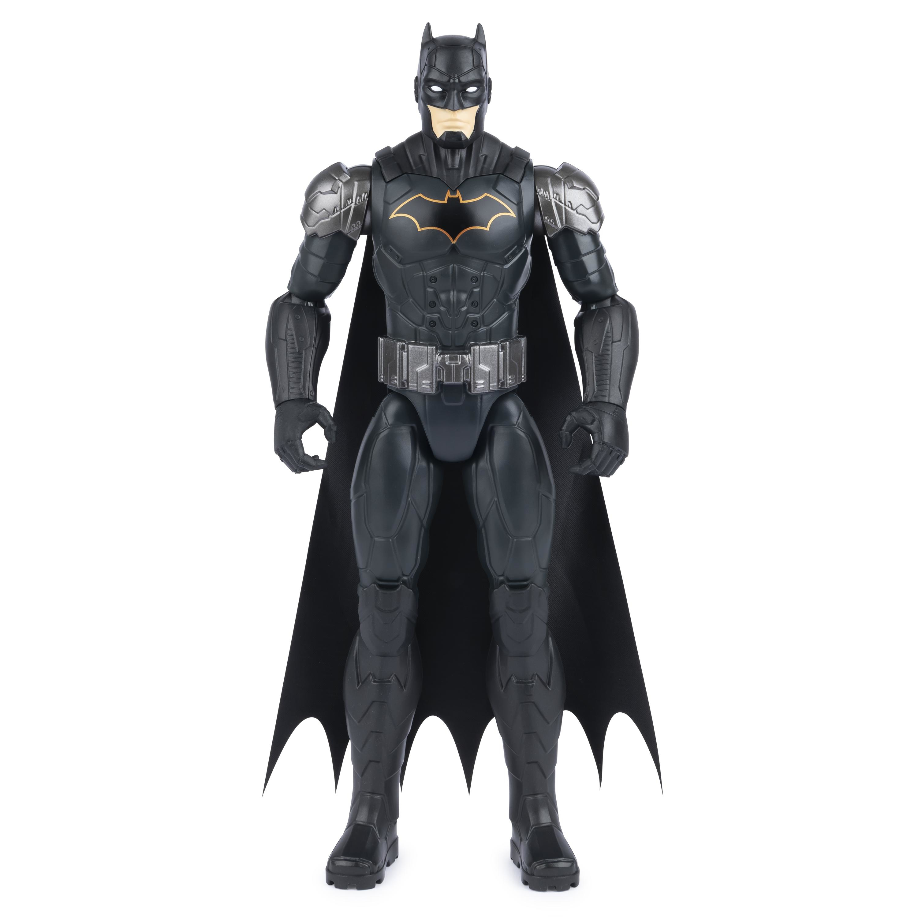 Figura de acción de Batman con traje negro, armadura y capa. Sobre superficie blanca.