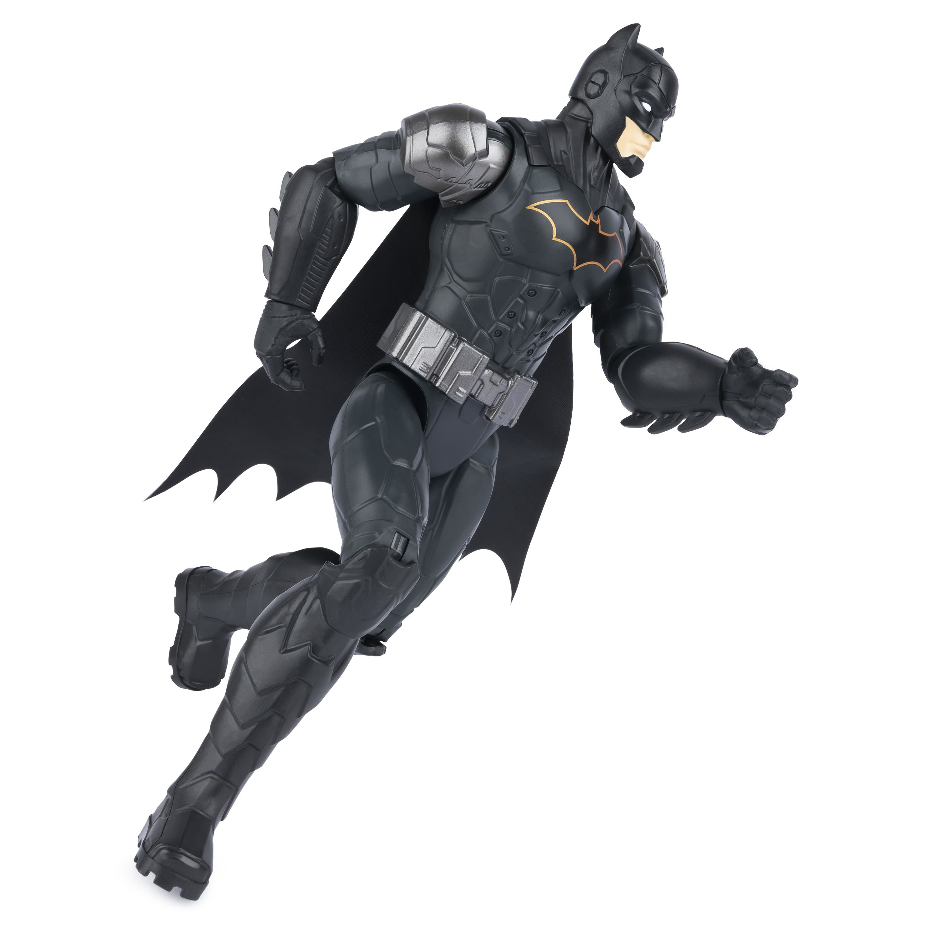 Figura de acción de Batman en el aire, traje negro, capa y detalles de armadura. Fondo blanco.