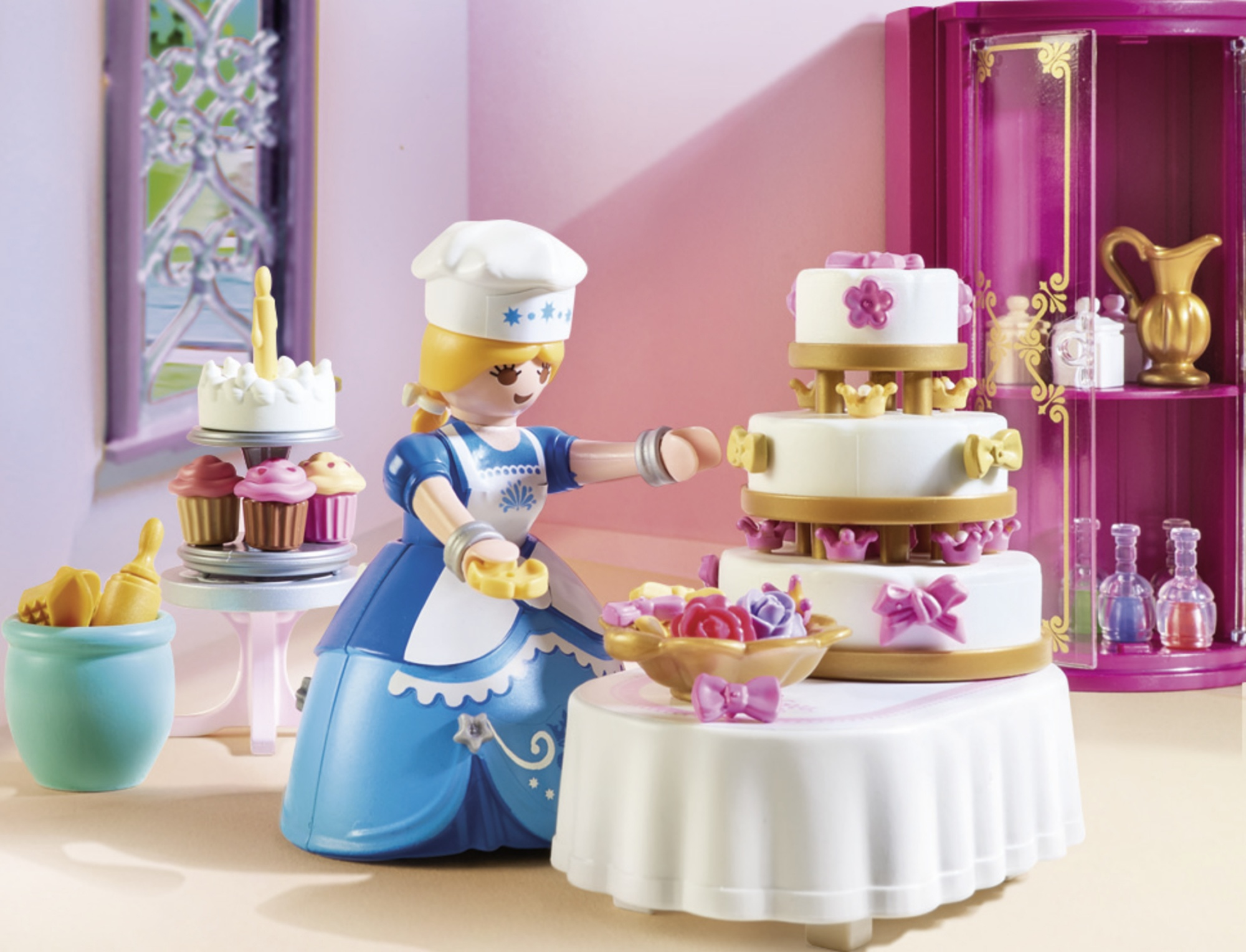 Escena de repostería de princesa Playmobil con una figura de princesa decorando un pastel.