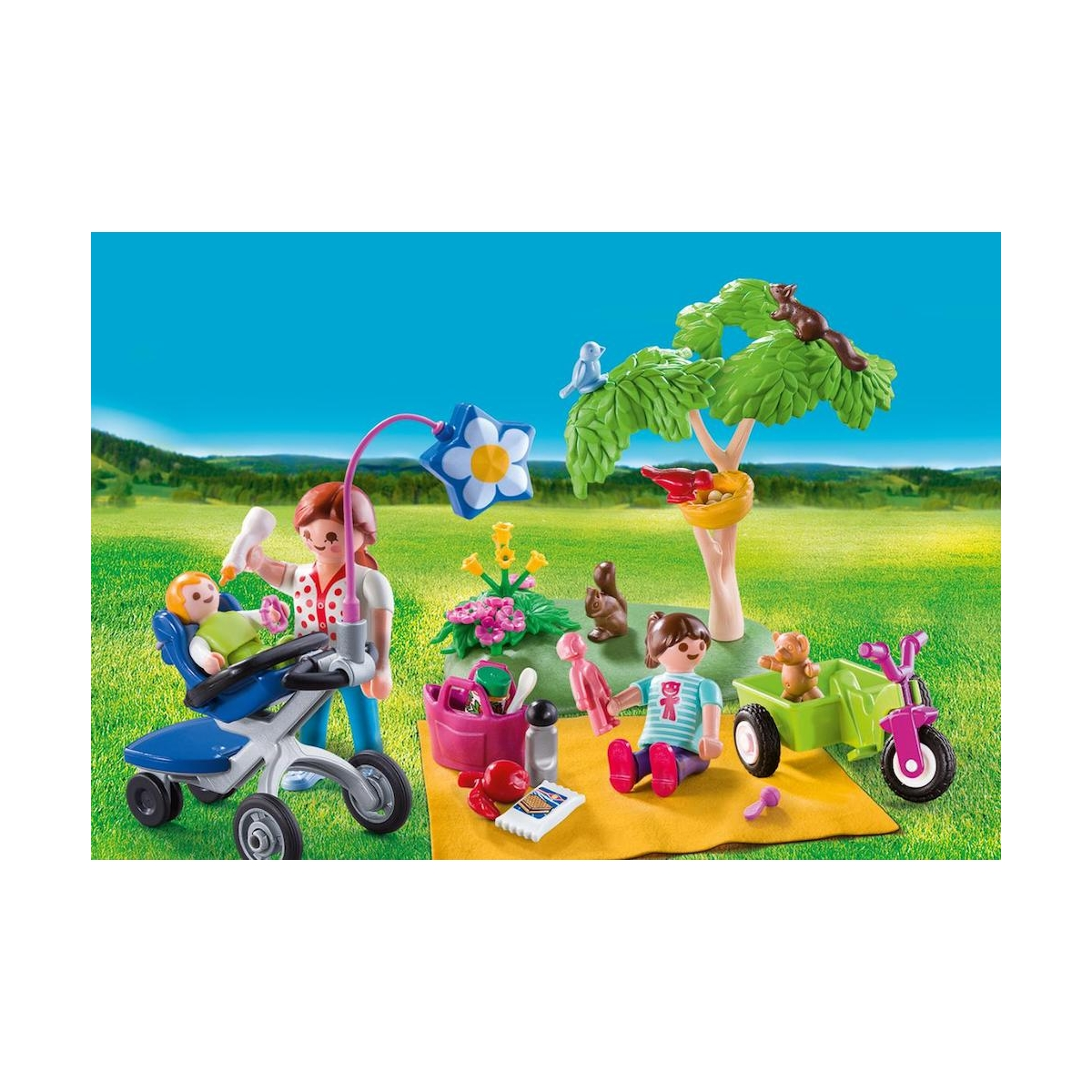 Una scena di picnic familiare Playmobil. Include un passeggino, un cestino da picnic, un carretto, un albero e diverse figure Playmobil.