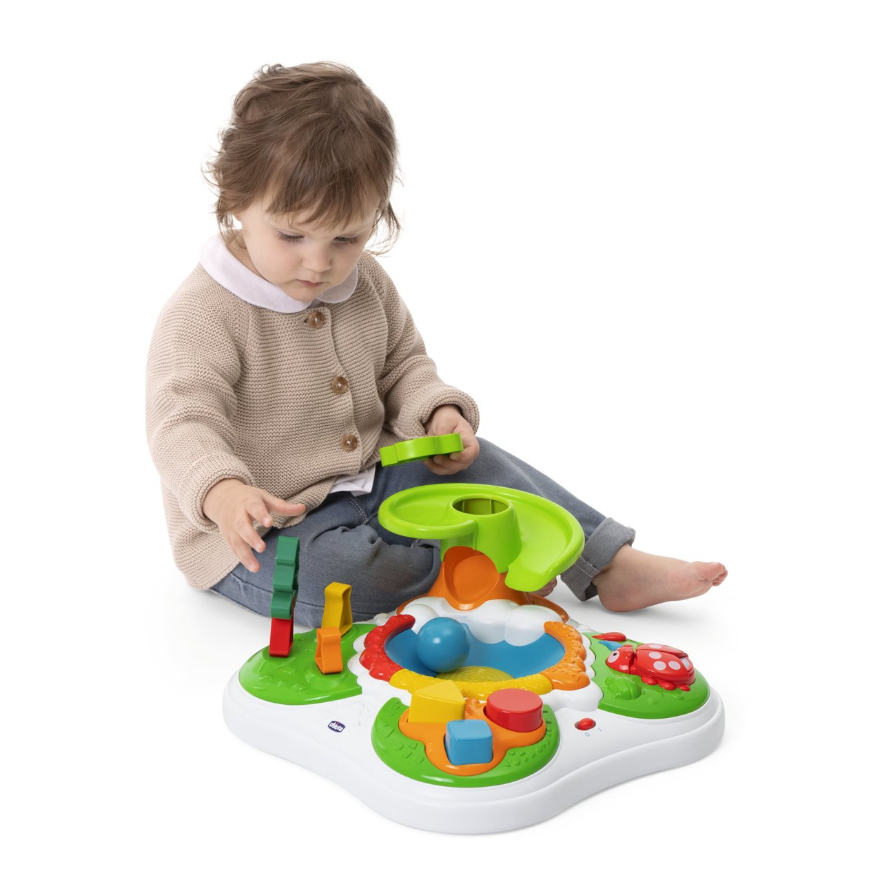 Dziecko bawi się zabawką. Zabawka ma zjeżdżalnię, kulki, kształty i biedronkę.