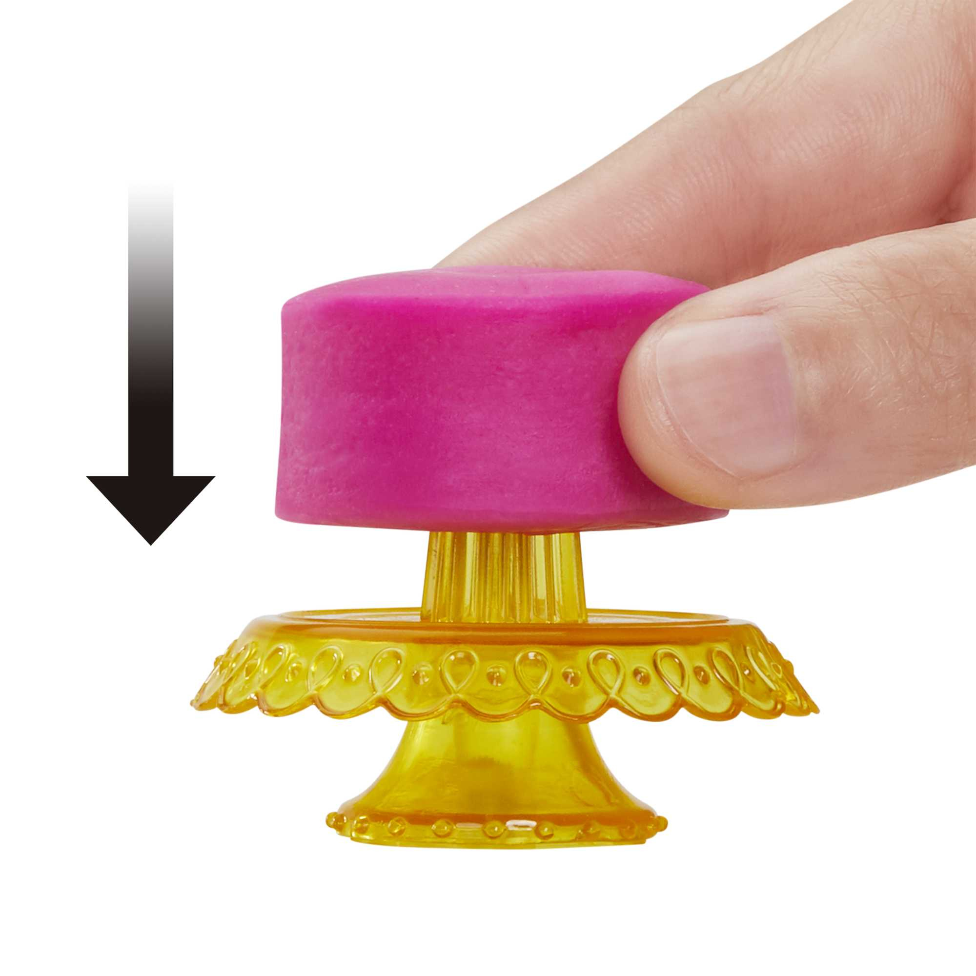 Hand setzt rosa Kuchendeckel auf gelben Kuchenständer. Pfeil sichtbar.