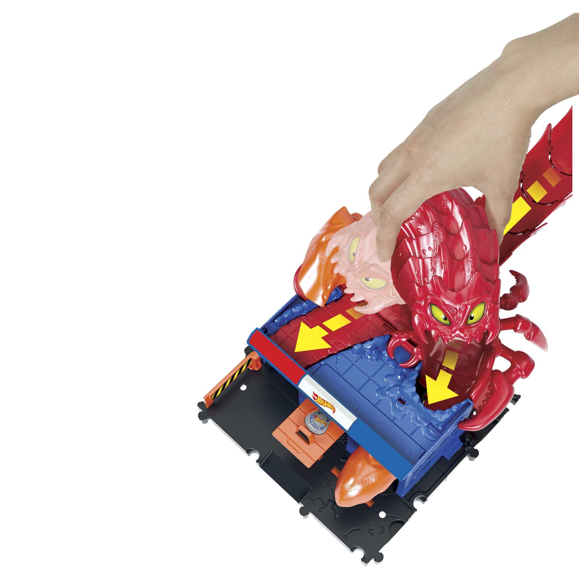 Eine Hand schiebt ein rotes Spielzeugmonster. Das Spielzeug ist Teil eines Hot Wheels Spielsets.