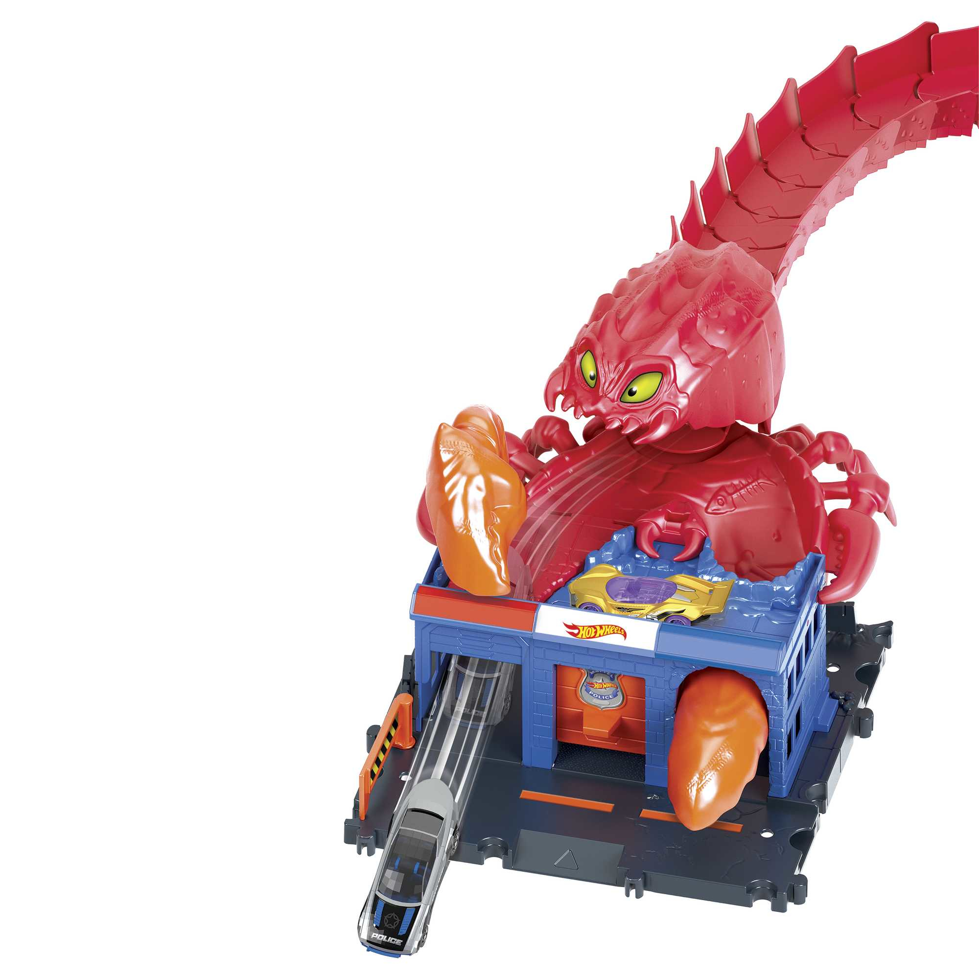 Ein Hot Wheels Streckenset mit einer roten Monsterfigur. Ein blaues Gebäude und Autos sind zu sehen.
