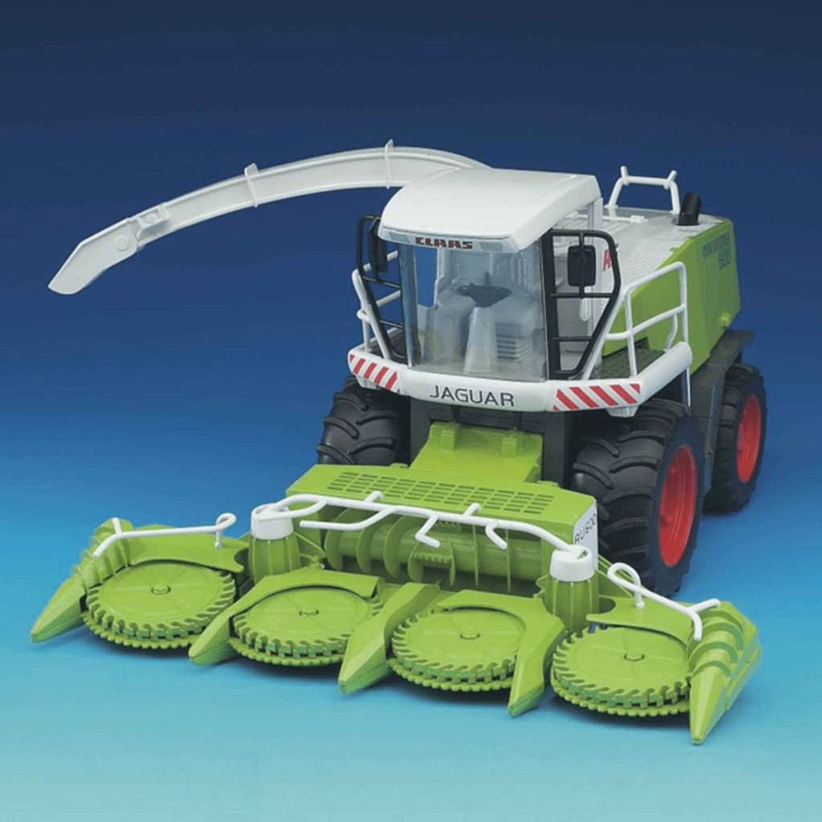 Zielona i biała zabawka Claas Jaguar 960 na niebieskim tle. Ma białą kabinę i czerwone koła.