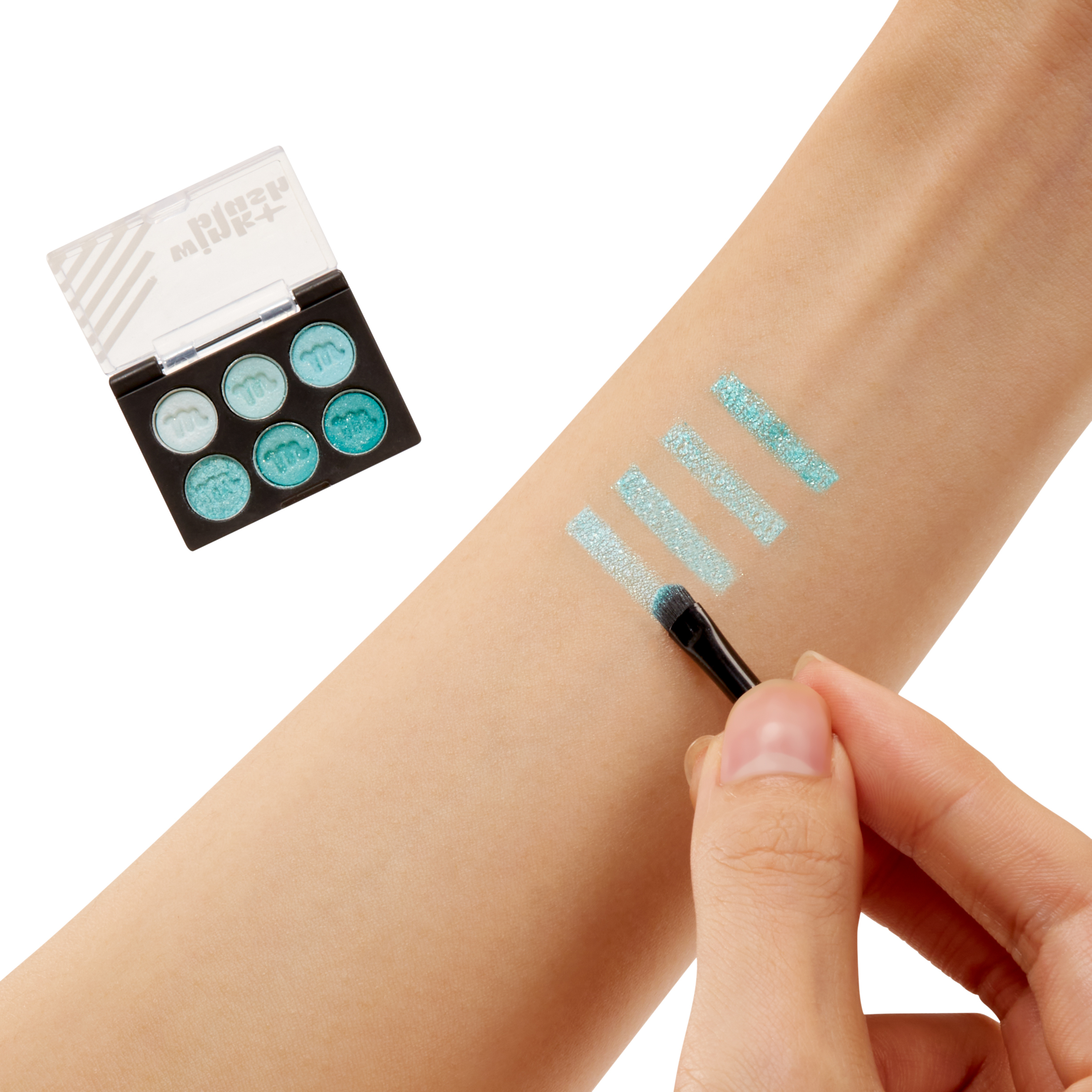 Zestaw kosmetyczny z cieniem do powiek. Paleta i pędzel są pokazane na białej powierzchni.