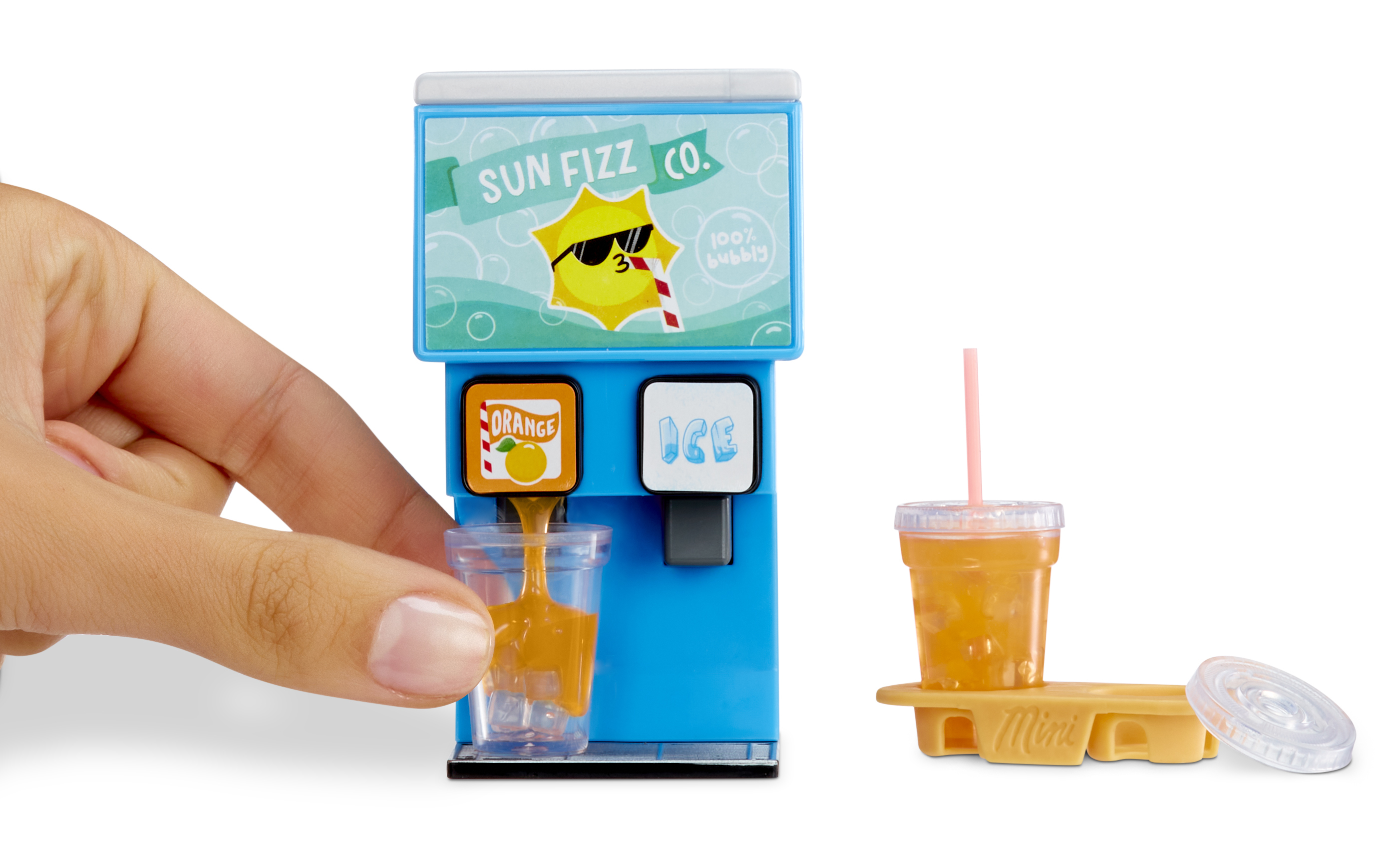 Ręka nalewa sok pomarańczowy do kubka z zabawkowego automatu do napojów. Obecny jest również kubek z lodem.