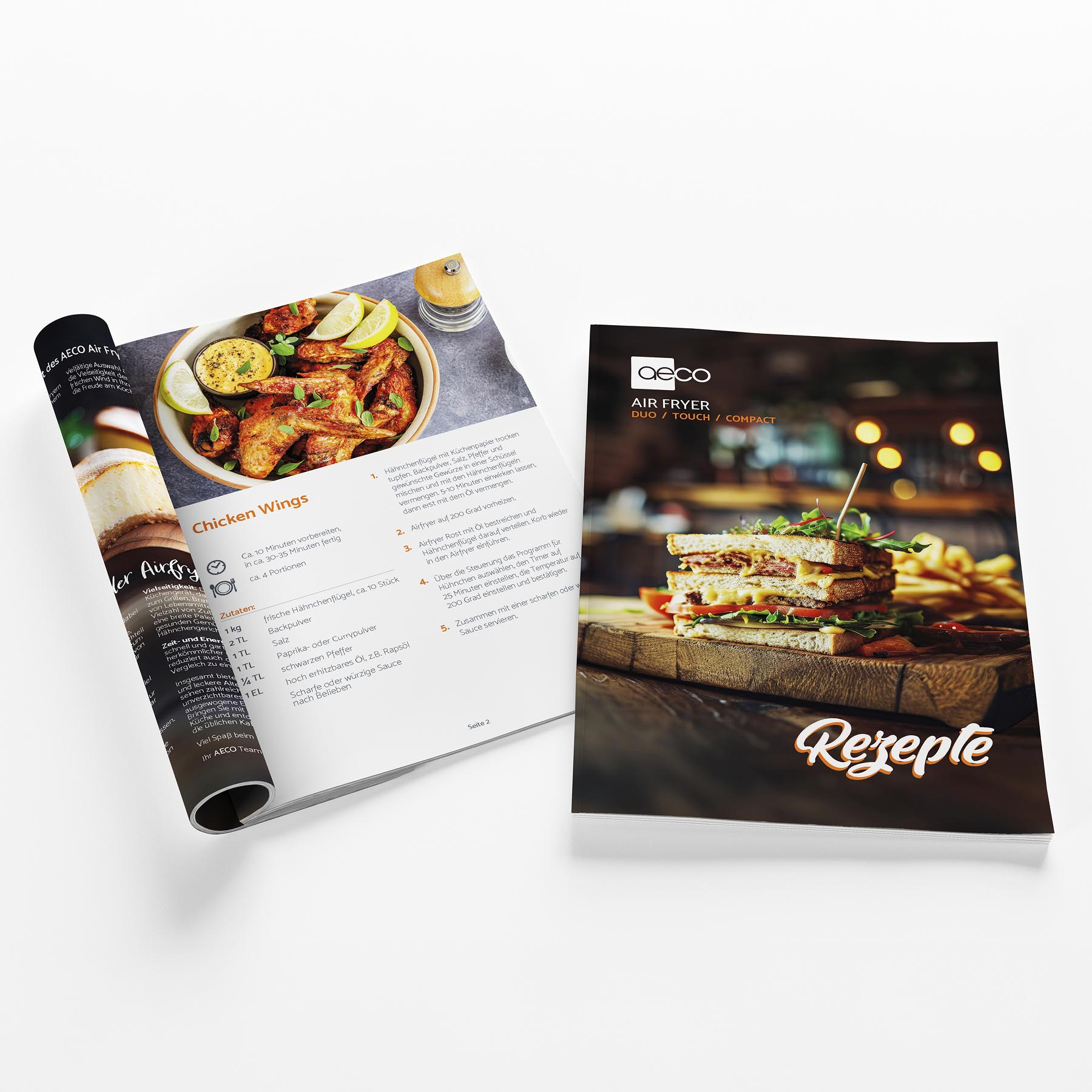 Offenes Magazin mit einem Rezept für Chicken Wings und ein Sandwich auf einem Holzbrett.