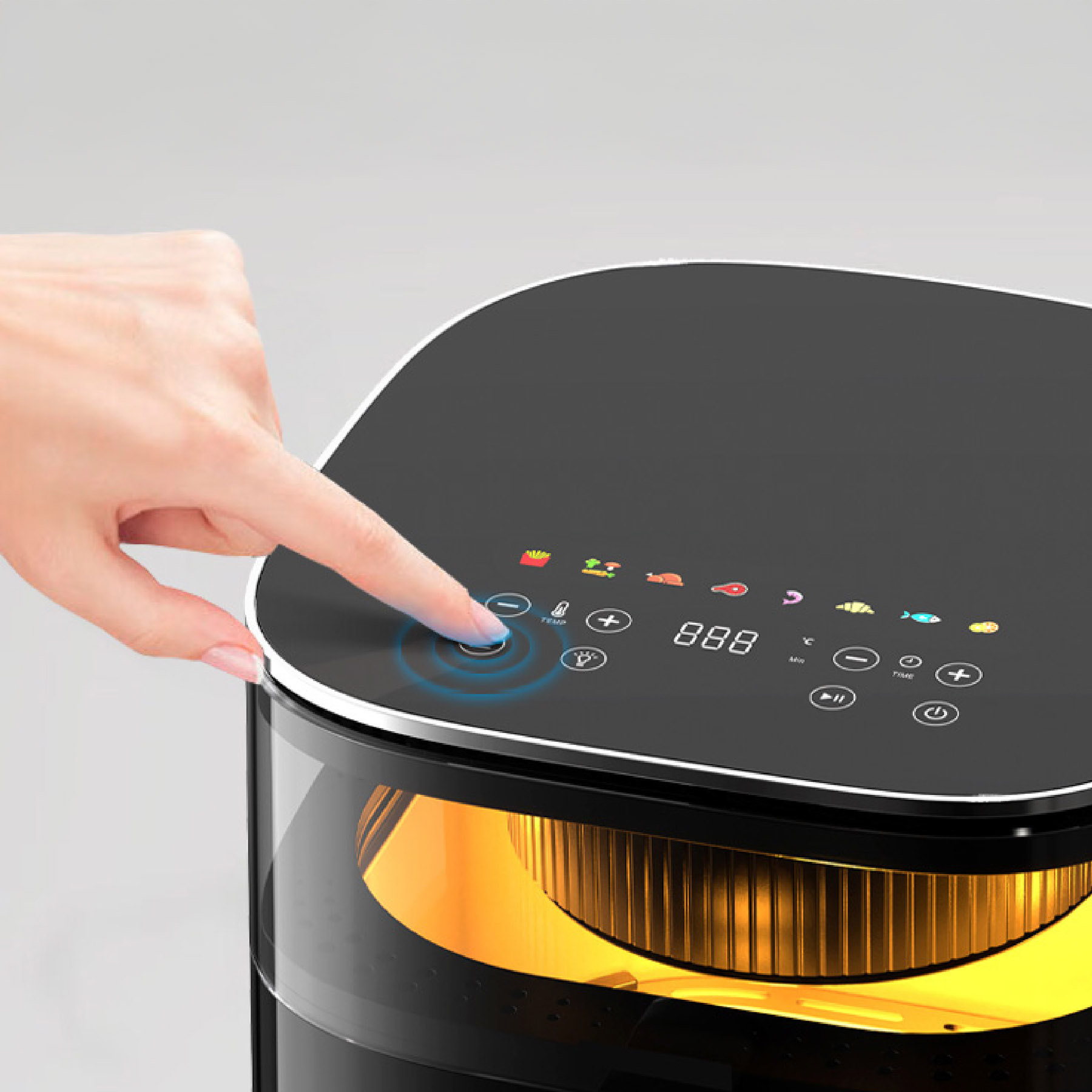 Eine Hand drückt einen Knopf an einer schwarzen Heißluftfritteuse mit beleuchtetem Touchscreen. Grauer Hintergrund.