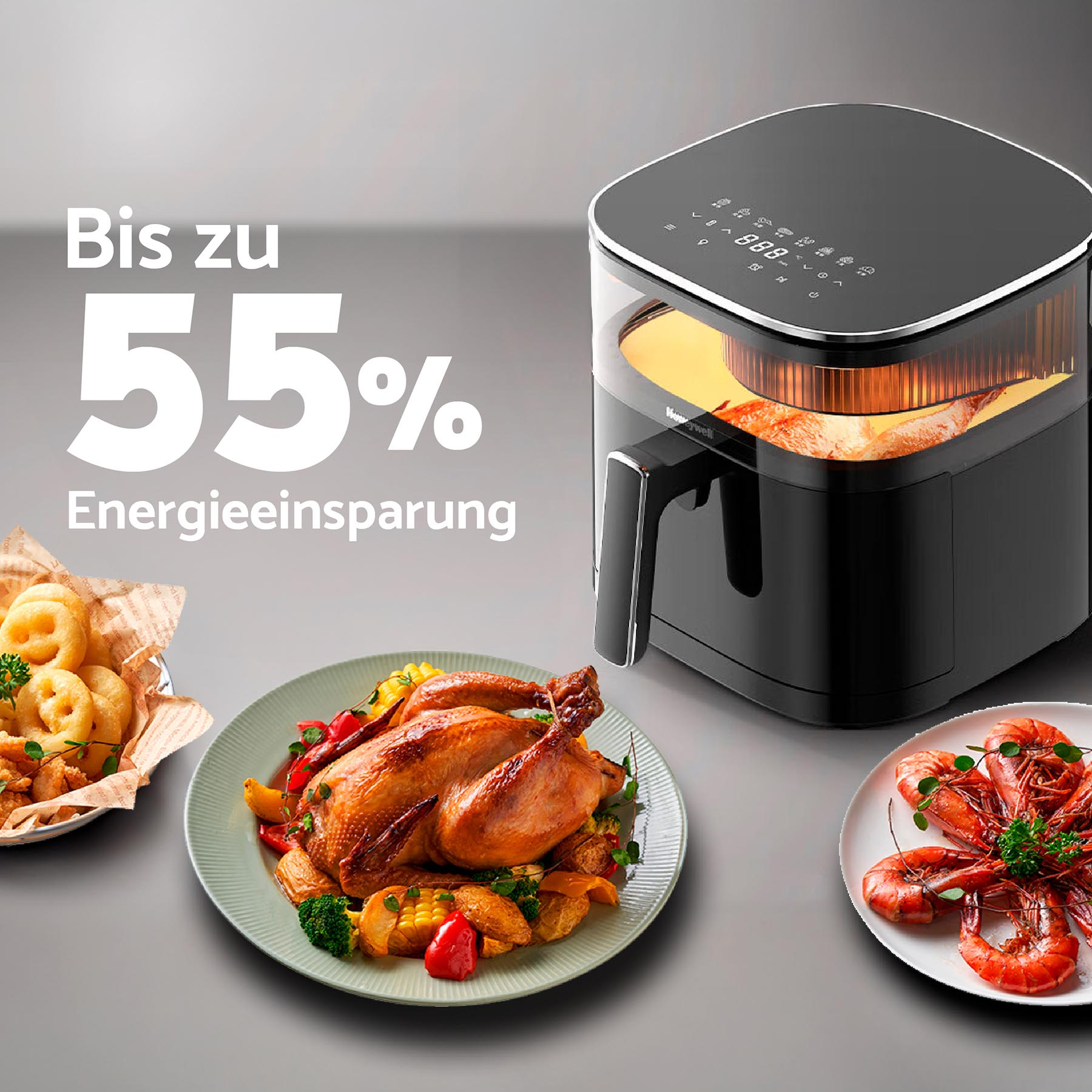 Schwarze Heißluftfritteuse mit Essen, darunter Hähnchen, Garnelen und Zwiebelringe. Grauer Hintergrund.