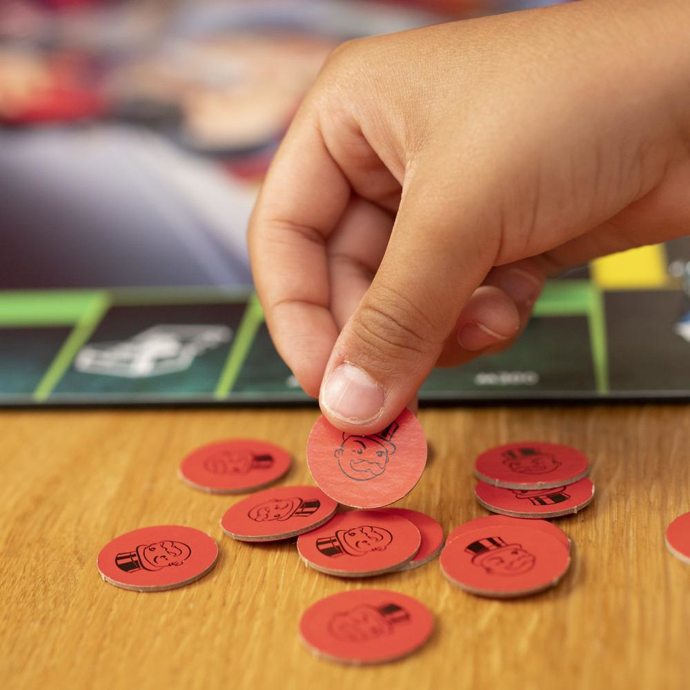 Eine Hand hält ein rotes Monopoly-Spielsymbol mit einem Mann mit Zylinder.