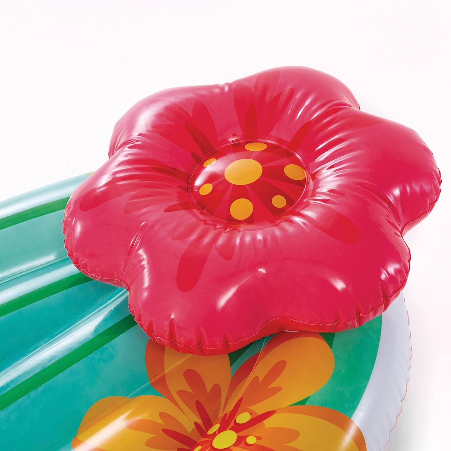 Fiore rosso gonfiabile su un tappetino a strisce turchese e bianco.