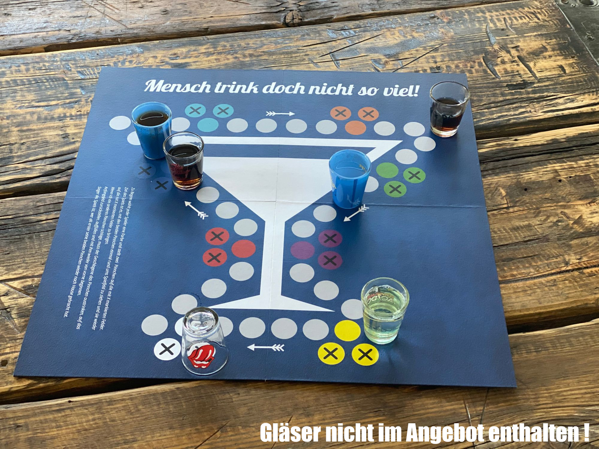 Brettspiel mit Schnapsgläsern auf einem Tisch, Anleitung auf Deutsch.
