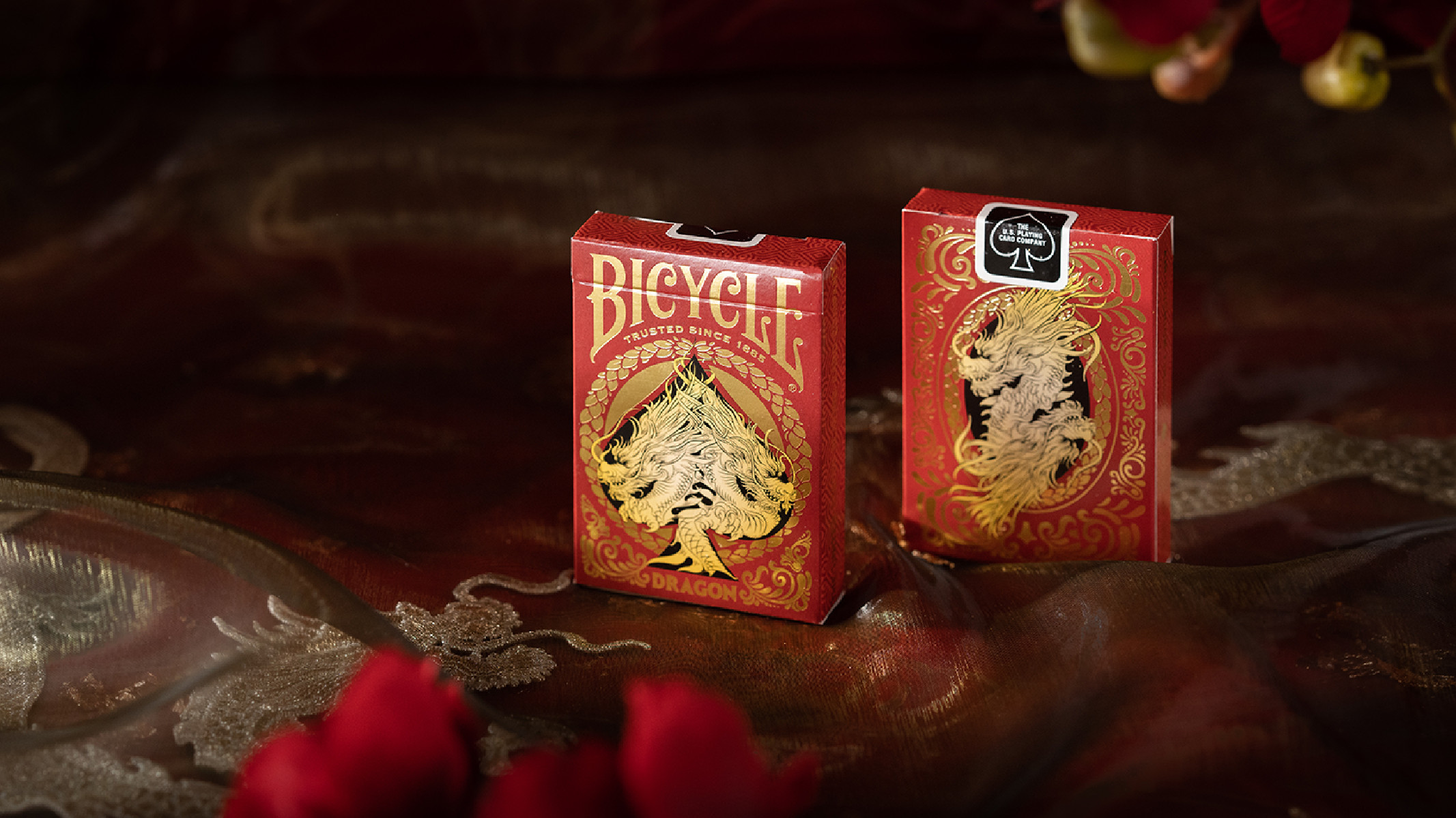Zwei rote Bicycle Dragon Spielkartenboxen auf dunklem Hintergrund.