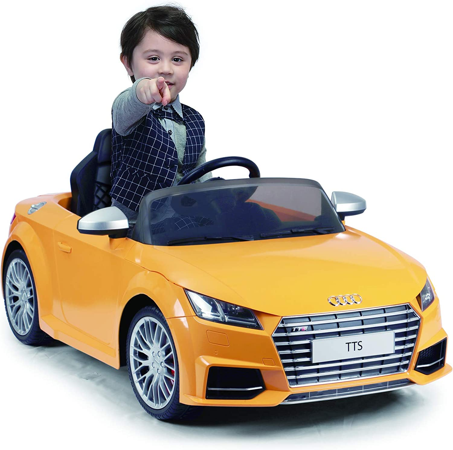 Ein Kind in einem orangen Spielzeugauto, das zeigt, mit weißem Hintergrund.