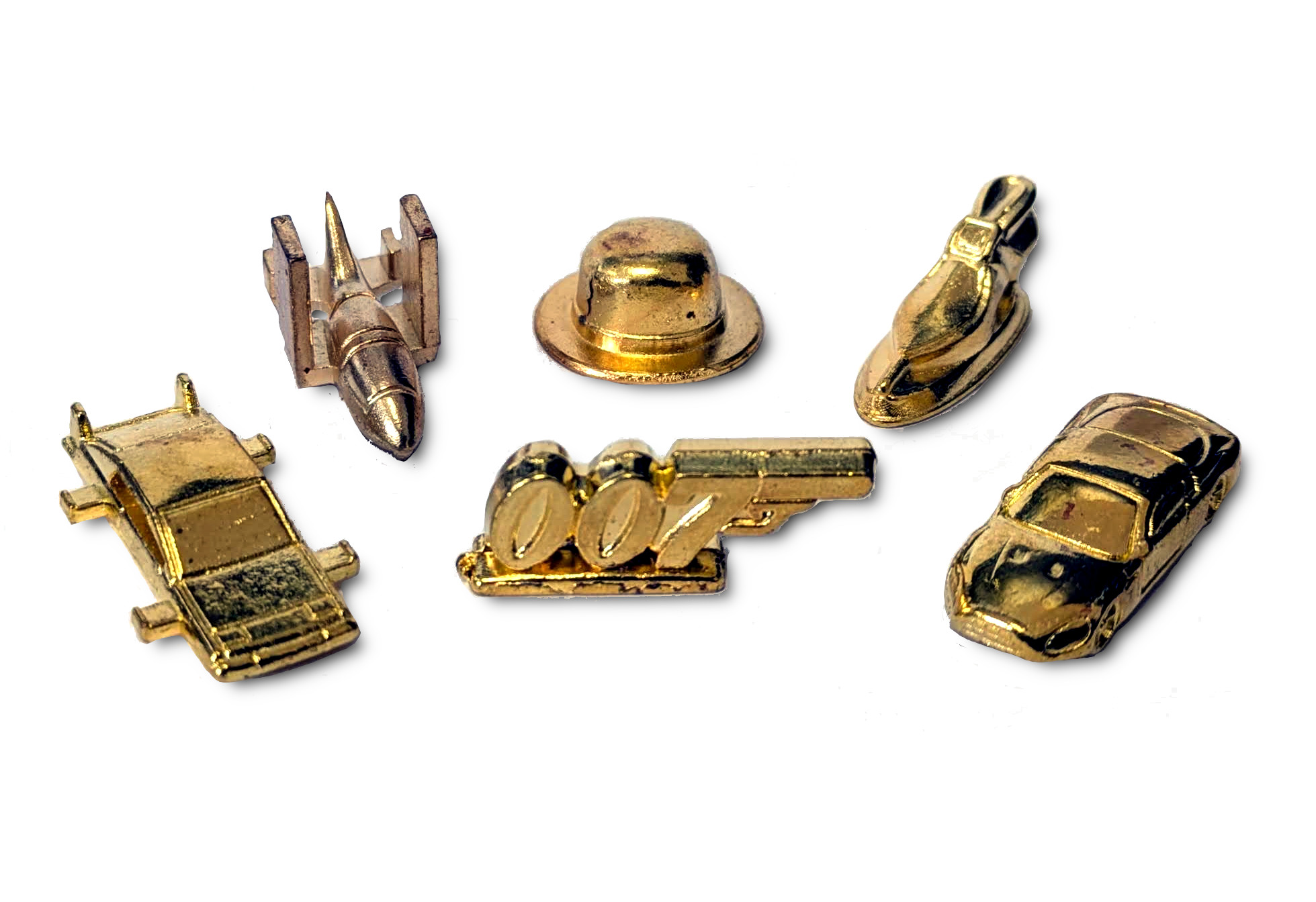 Goldene Spielsteine: Auto, Flugzeug, Hut, Rakete, Boot und Pistole, auf weißem Grund.