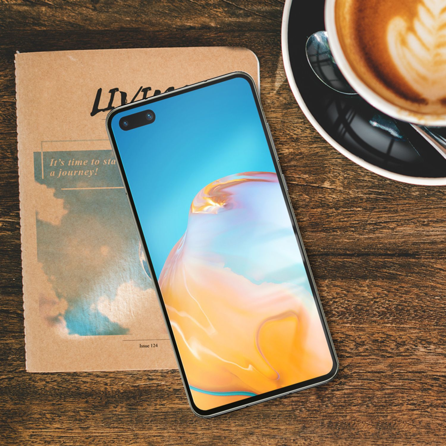 Un téléphone sur une table en bois avec une tasse de café et un livre.