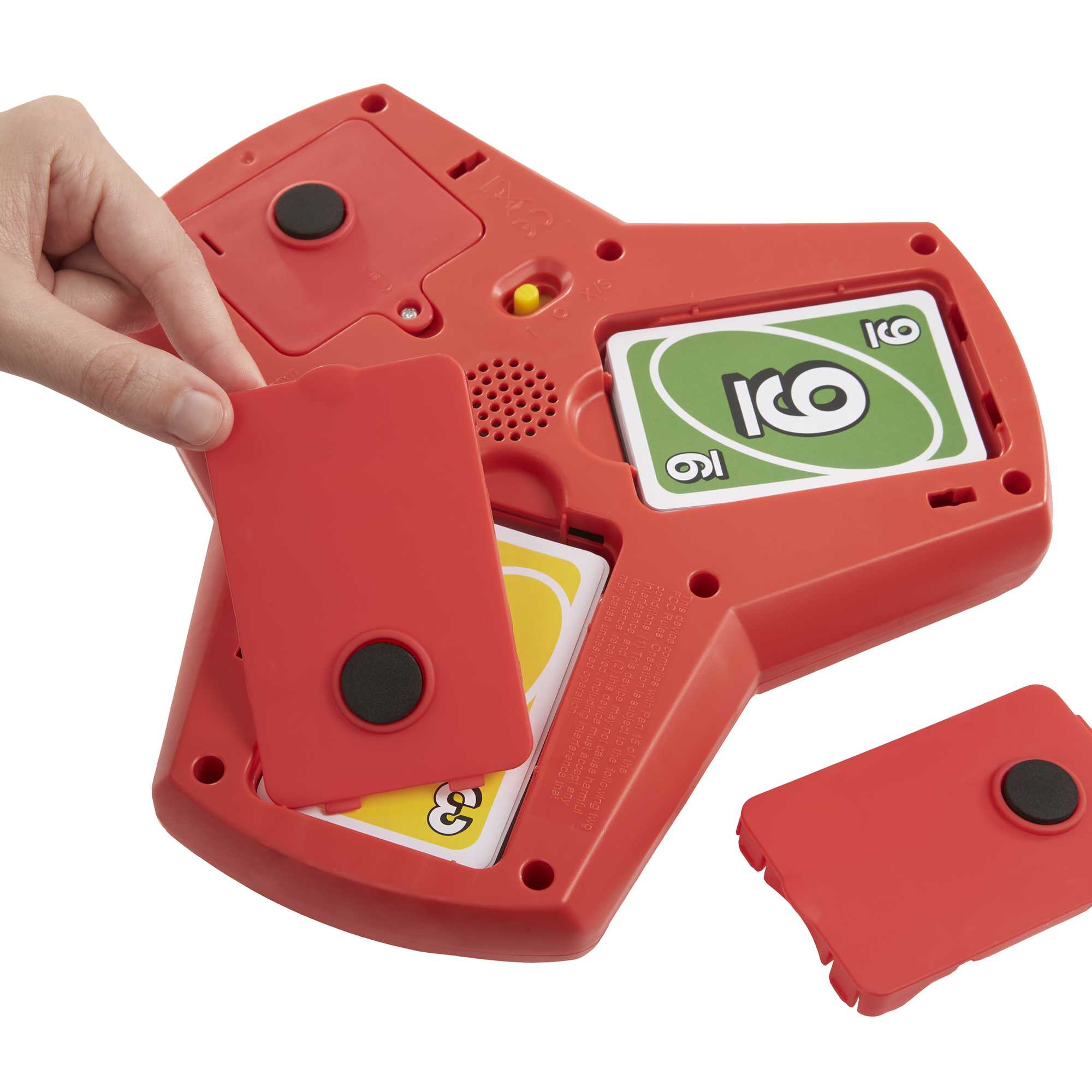 Eine Hand öffnet eine rote Spielkonsole und enthüllt Uno-Karten im Inneren. Eine rote Abdeckung liegt daneben.