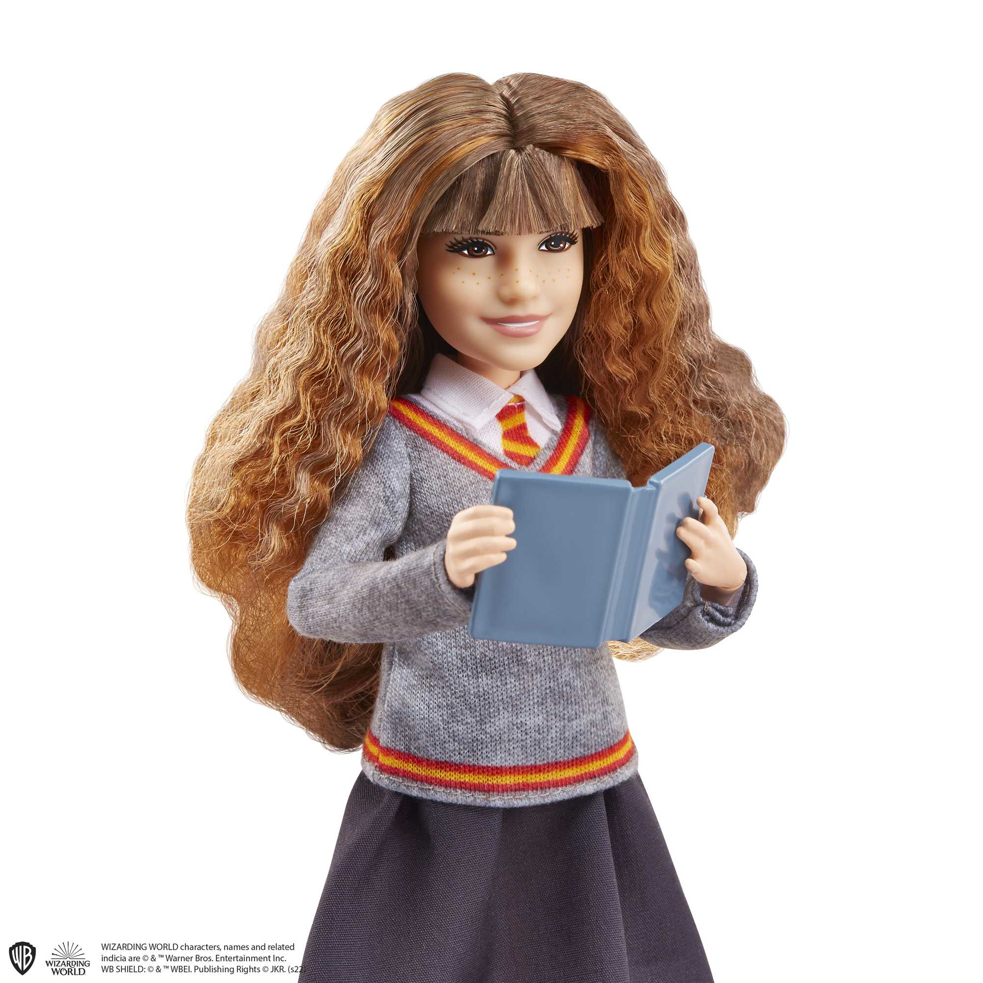 Eine Puppe von Hermine Granger in Schuluniform, die ein blaues Buch hält und lächelt.