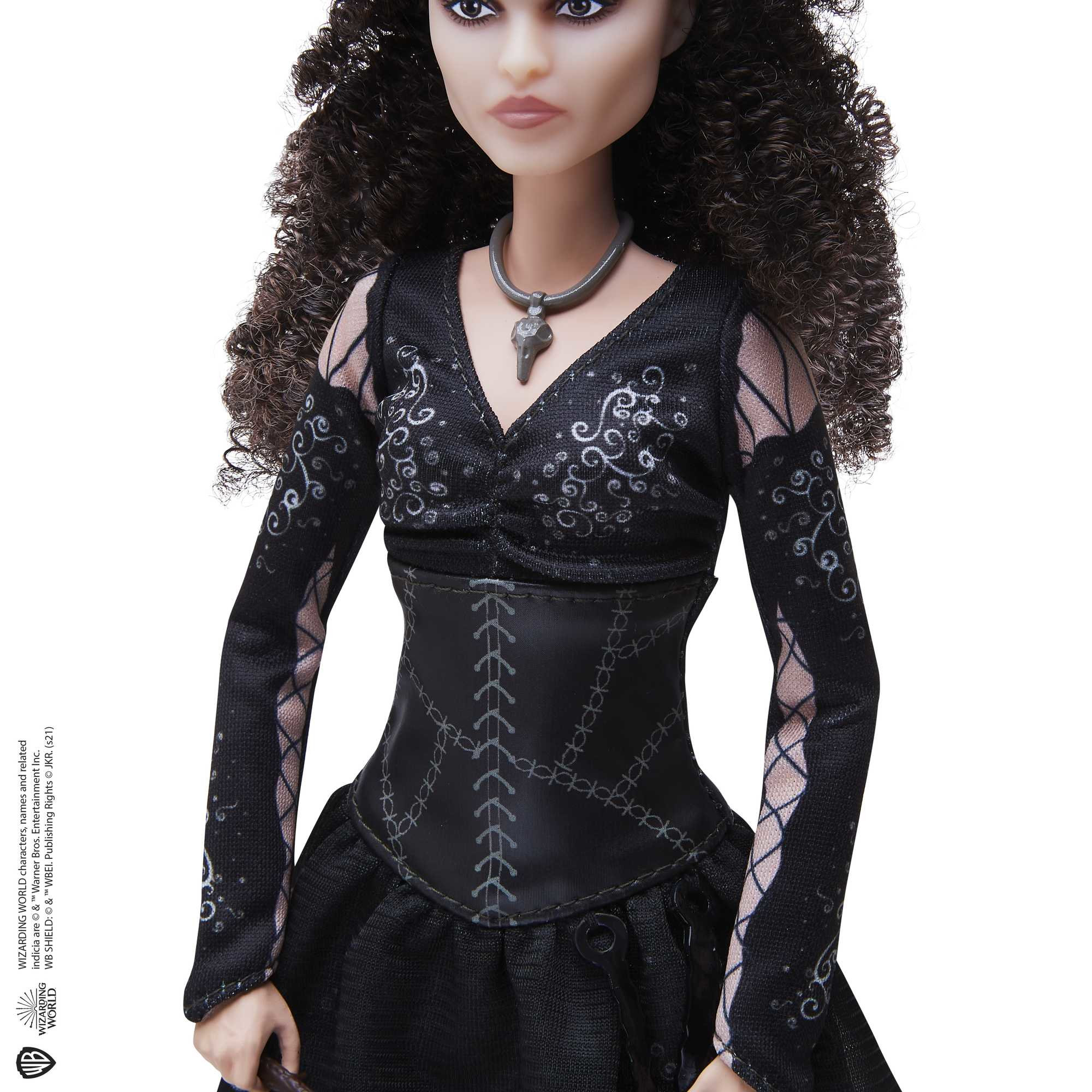Bambola con capelli castani ricci e vestito nero.