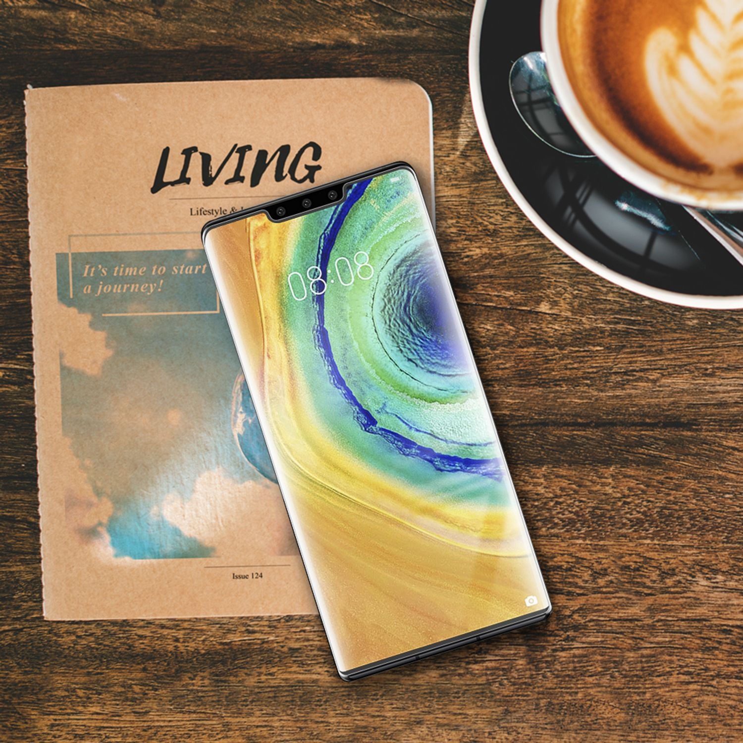 Smartphone sur une table en bois à côté d'un magazine et d'une tasse de café avec du latte art.