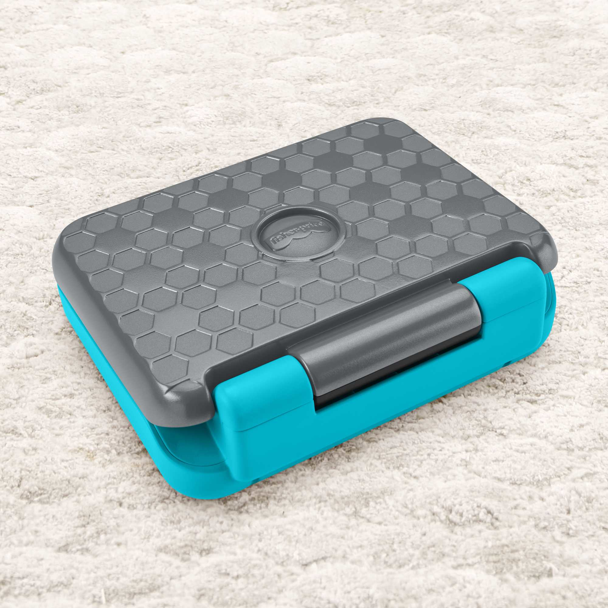 Szara i niebiesko-zielona zabawka lub pojemnik na neutralnej powierzchni. Górna część jest wzorzysta, a boki niebiesko-zielone.