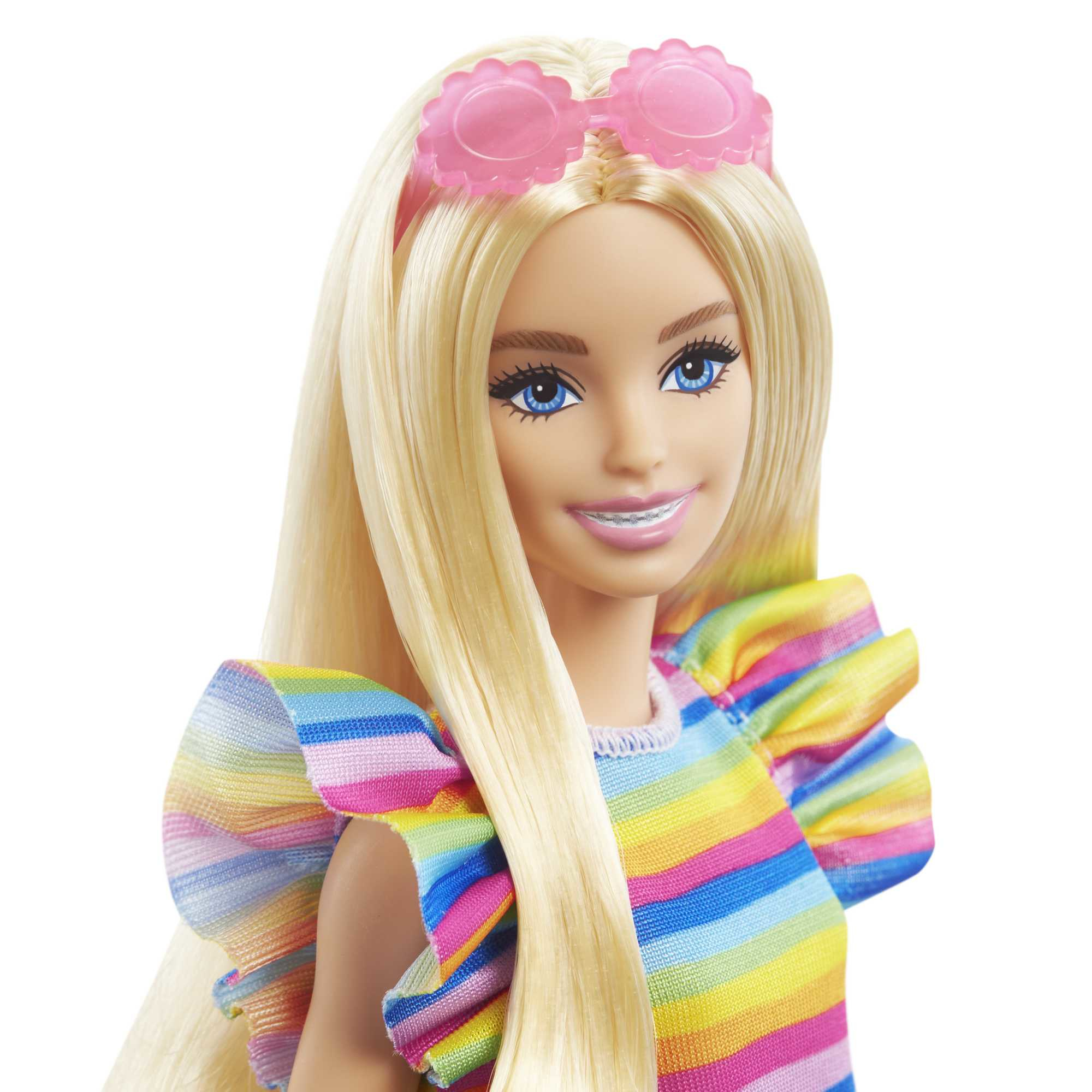 Blonde Barbie-Puppe mit Regenbogen-Streifenkleid und rosa Sonnenbrille auf dem Kopf.
