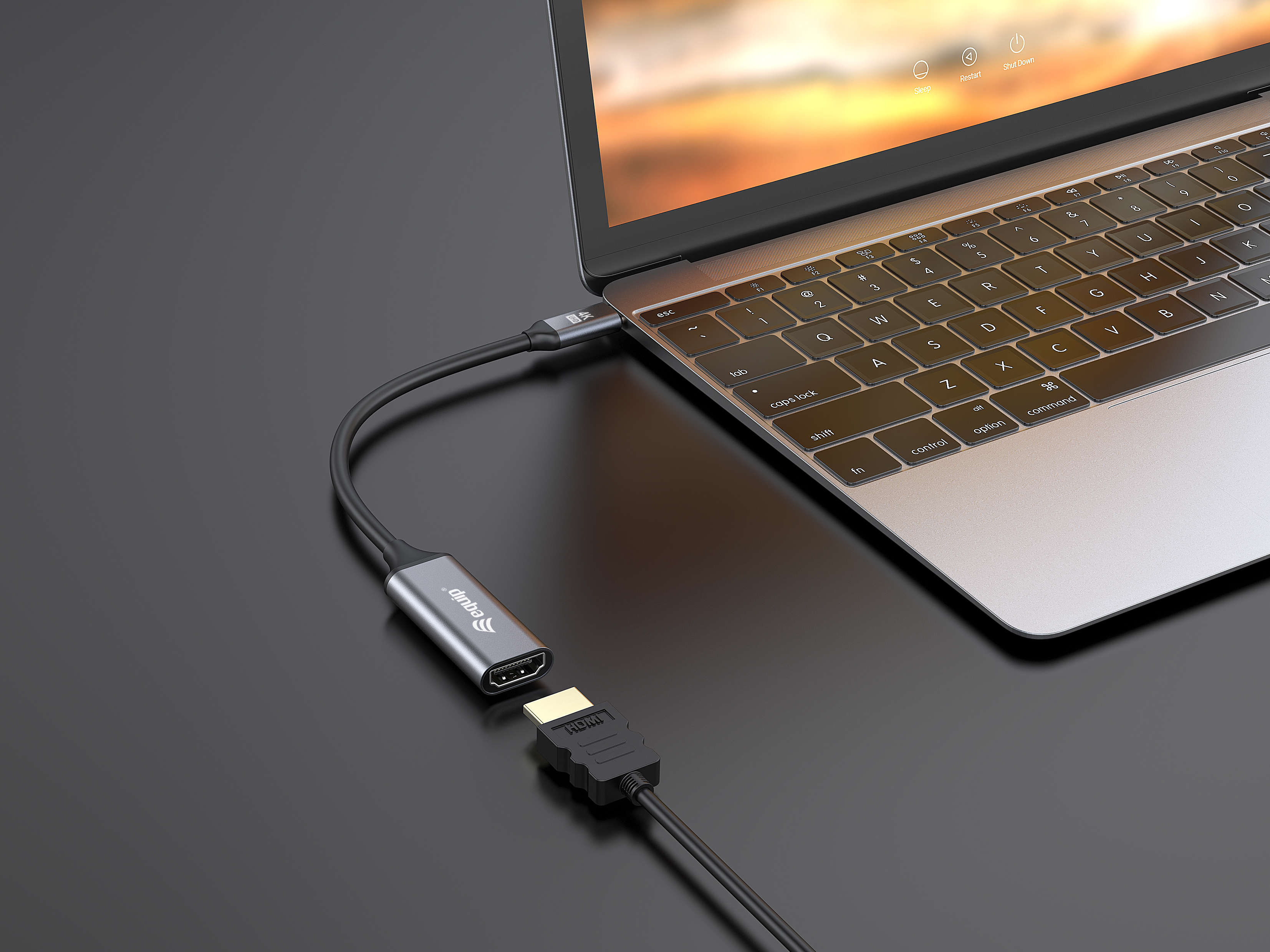 Portátil con cable HDMI conectado. Adaptador HDMI a la izquierda, superficie negra.